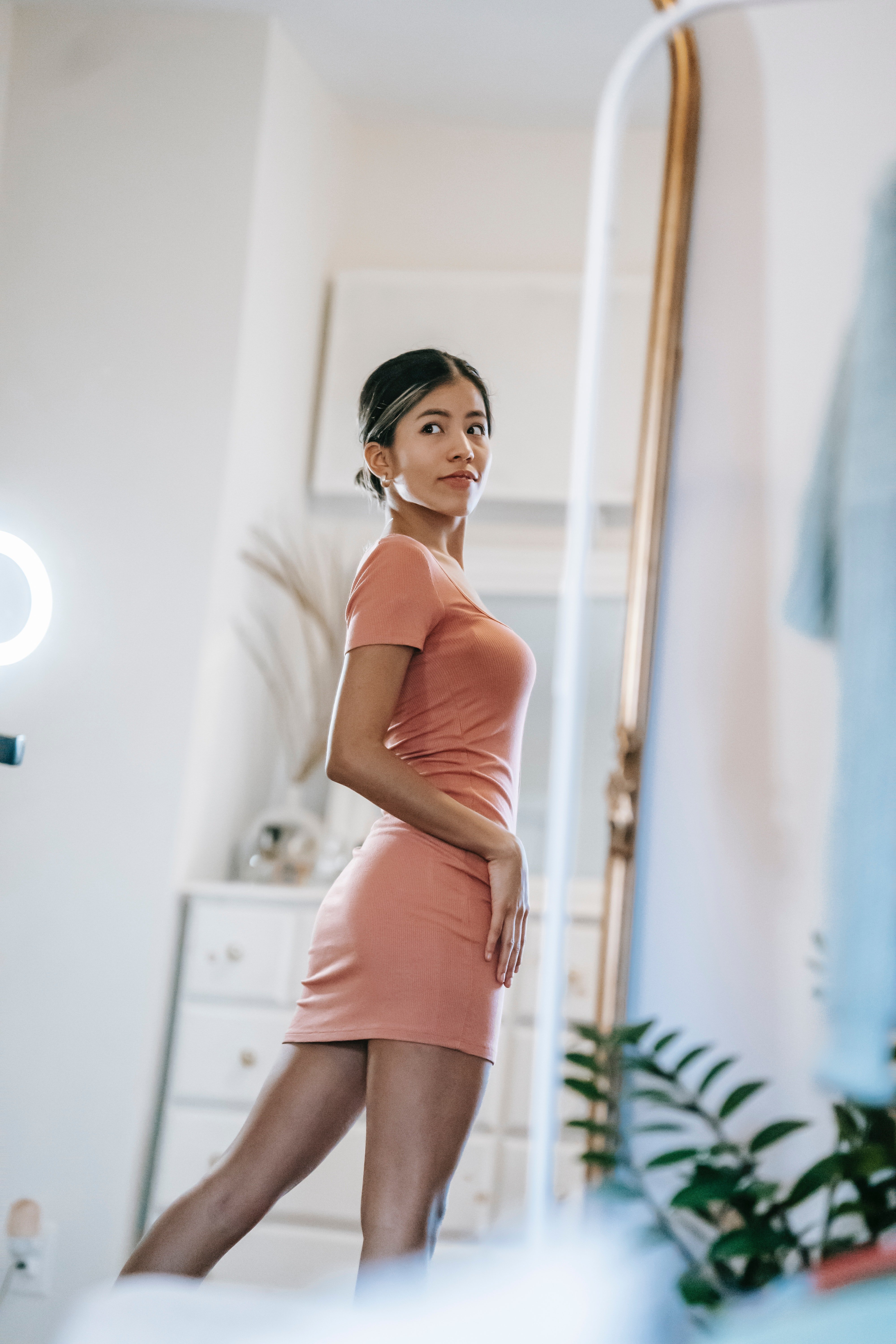 Gorgeous woman looking at a big mirror | Photo: Pexels