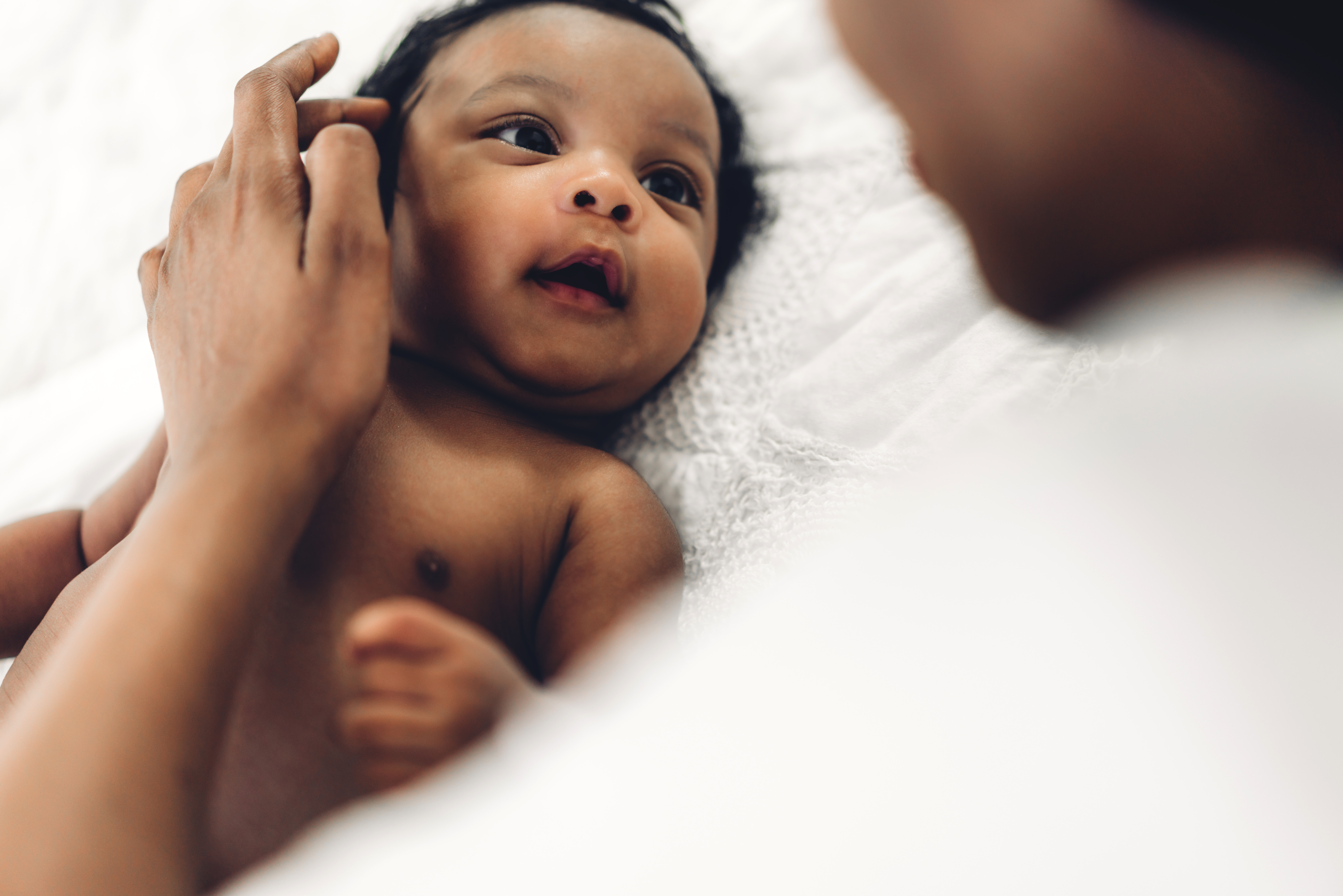 A woman caressing a newborn baby's face | Source: Shutterstock