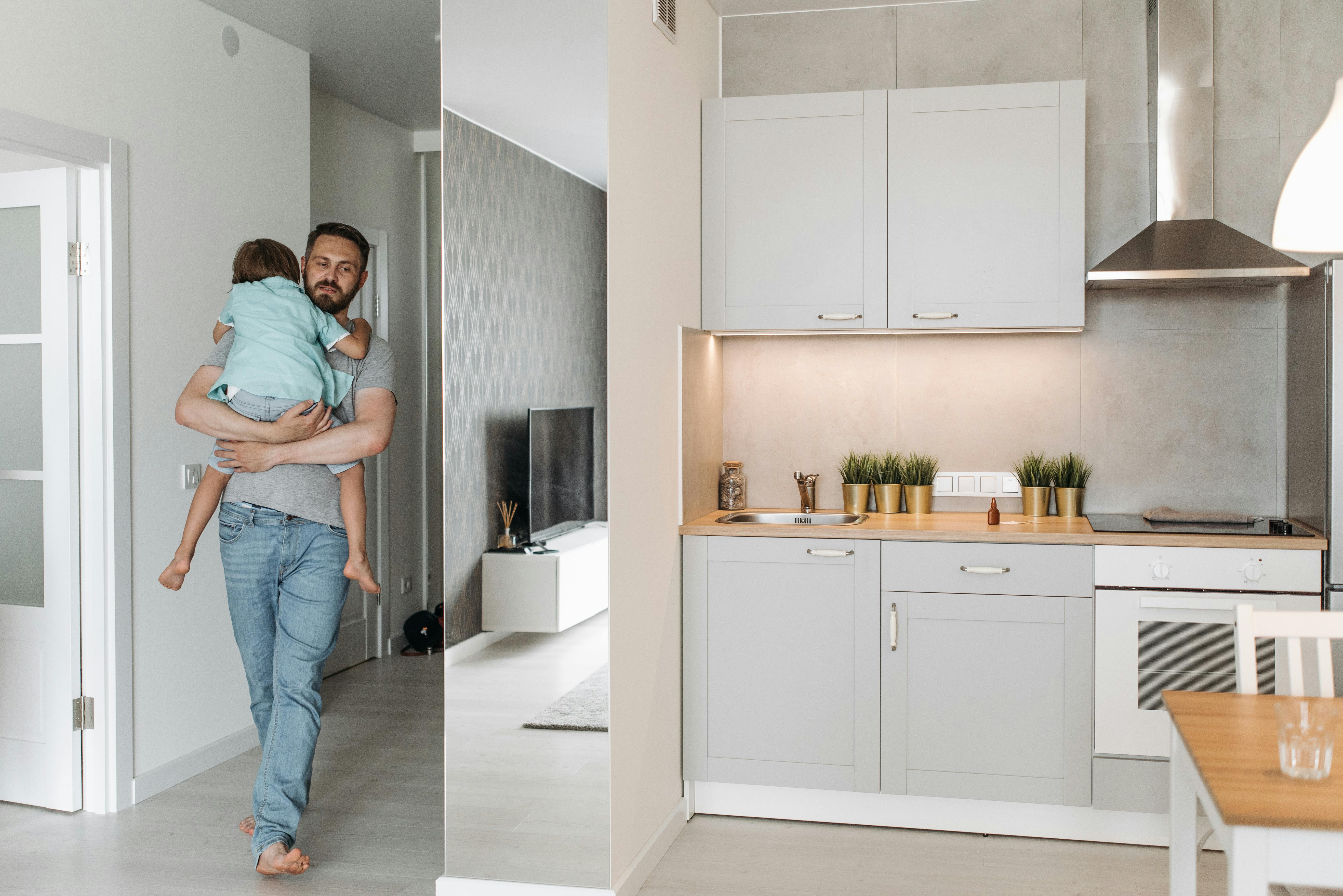 A man carrying a boy into a kitchen | Source: Pexels