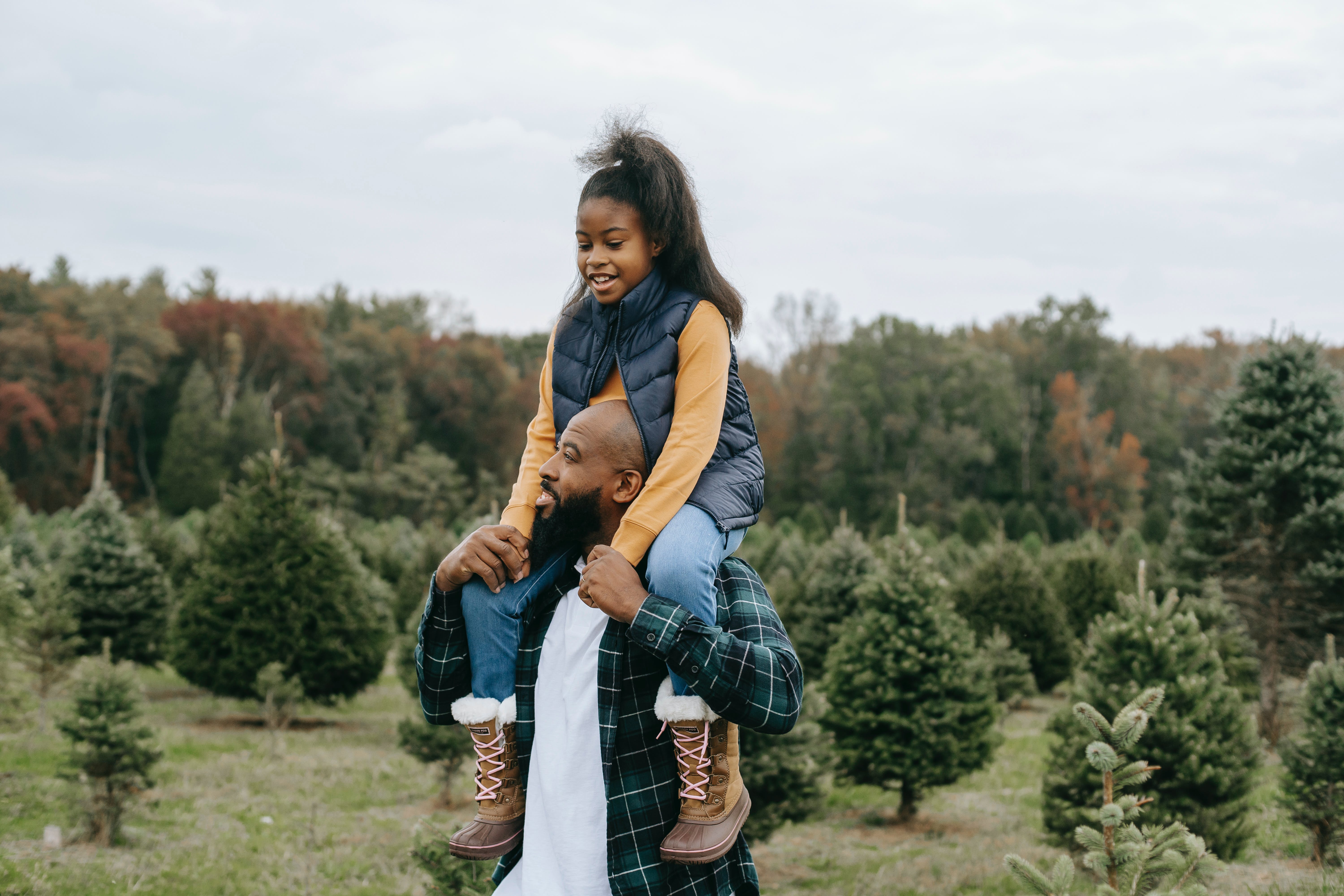 A man carrying his daughter on his shoulders. | Source: Pexels