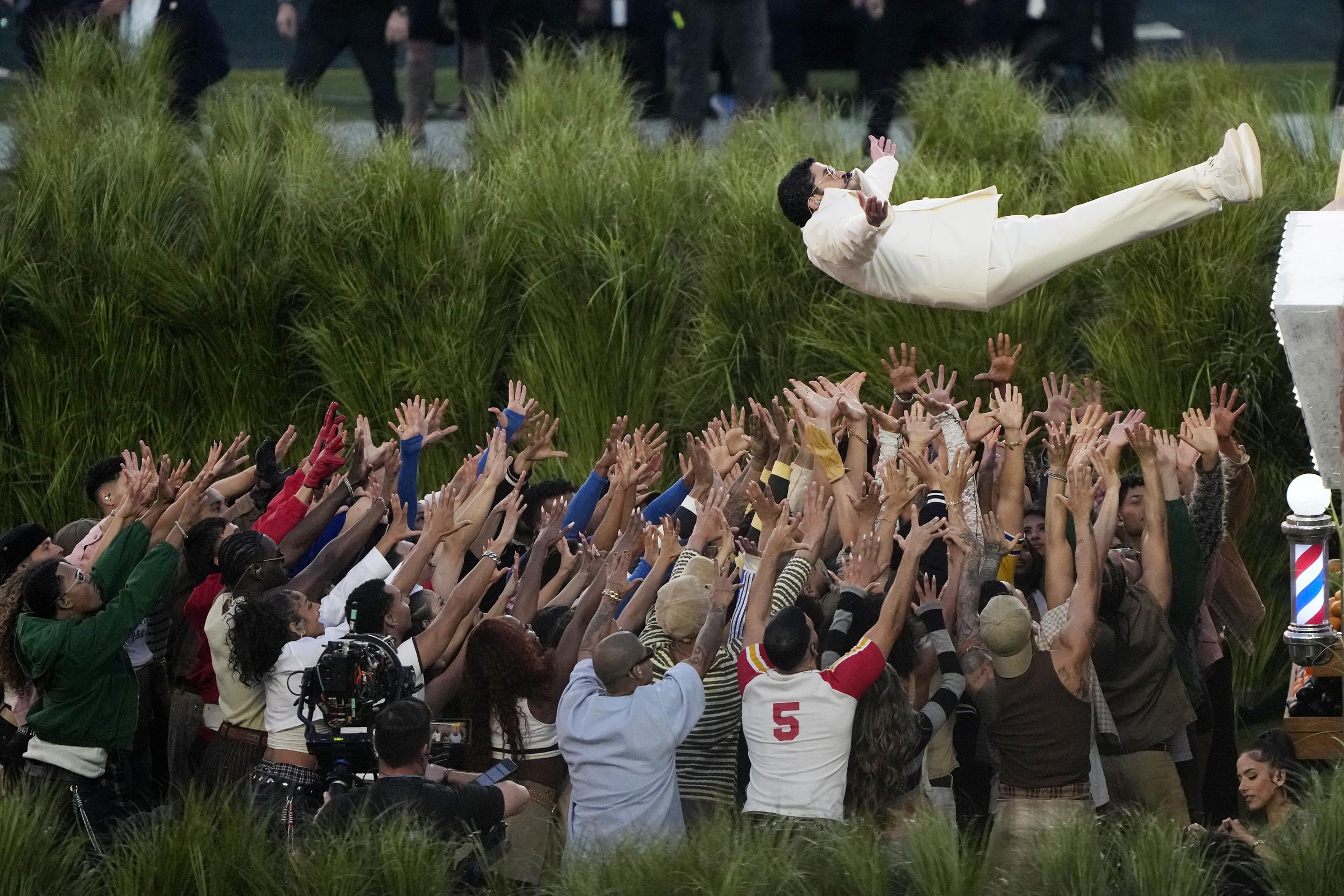 The Puerto Rican singer is lifted by dancers during the Apple Music Super Bowl LX Halftime Show, as part of a choreographed sequence performed on the field at Levi's Stadium.