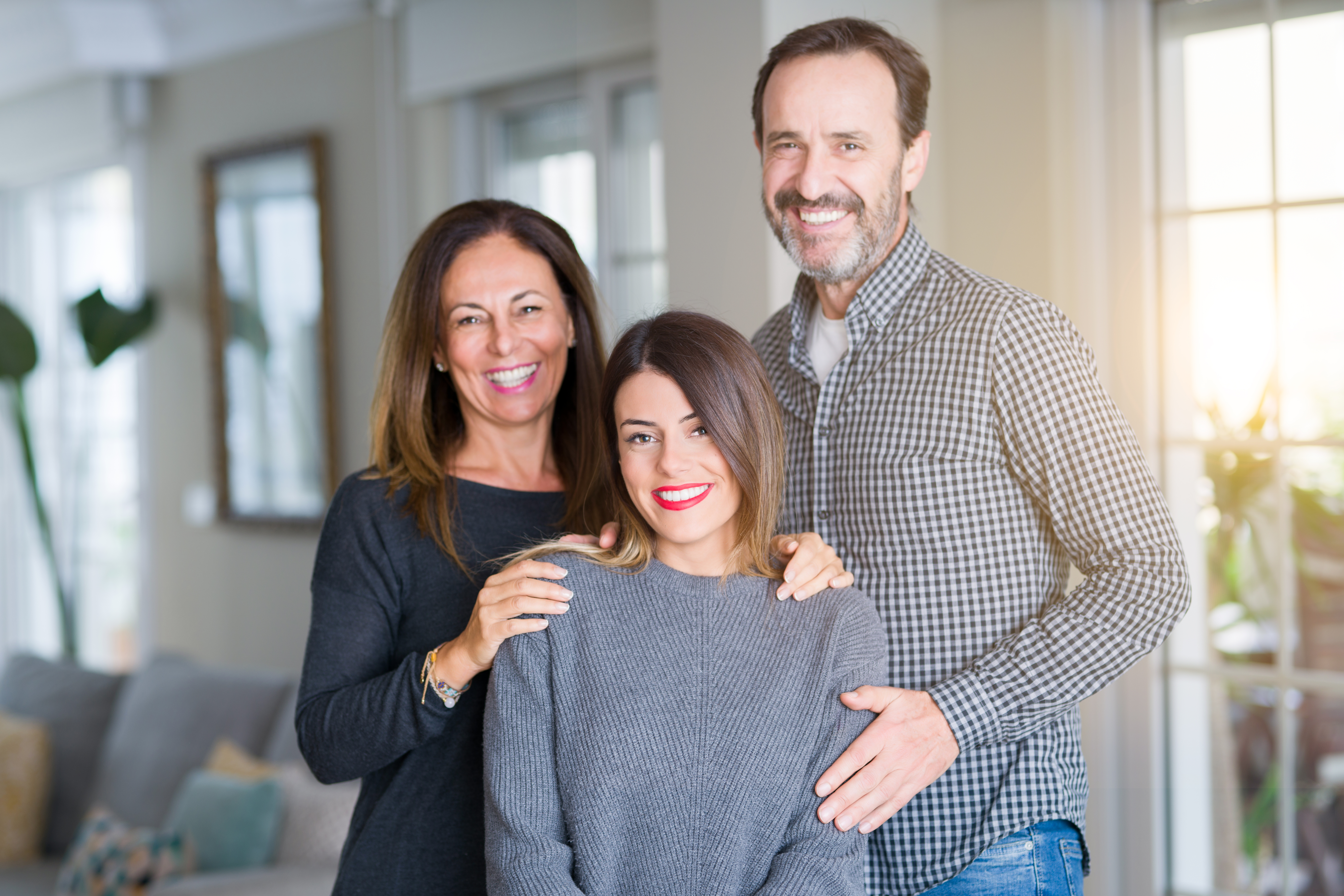 A girl standing with her parents | Source: Shutterstock