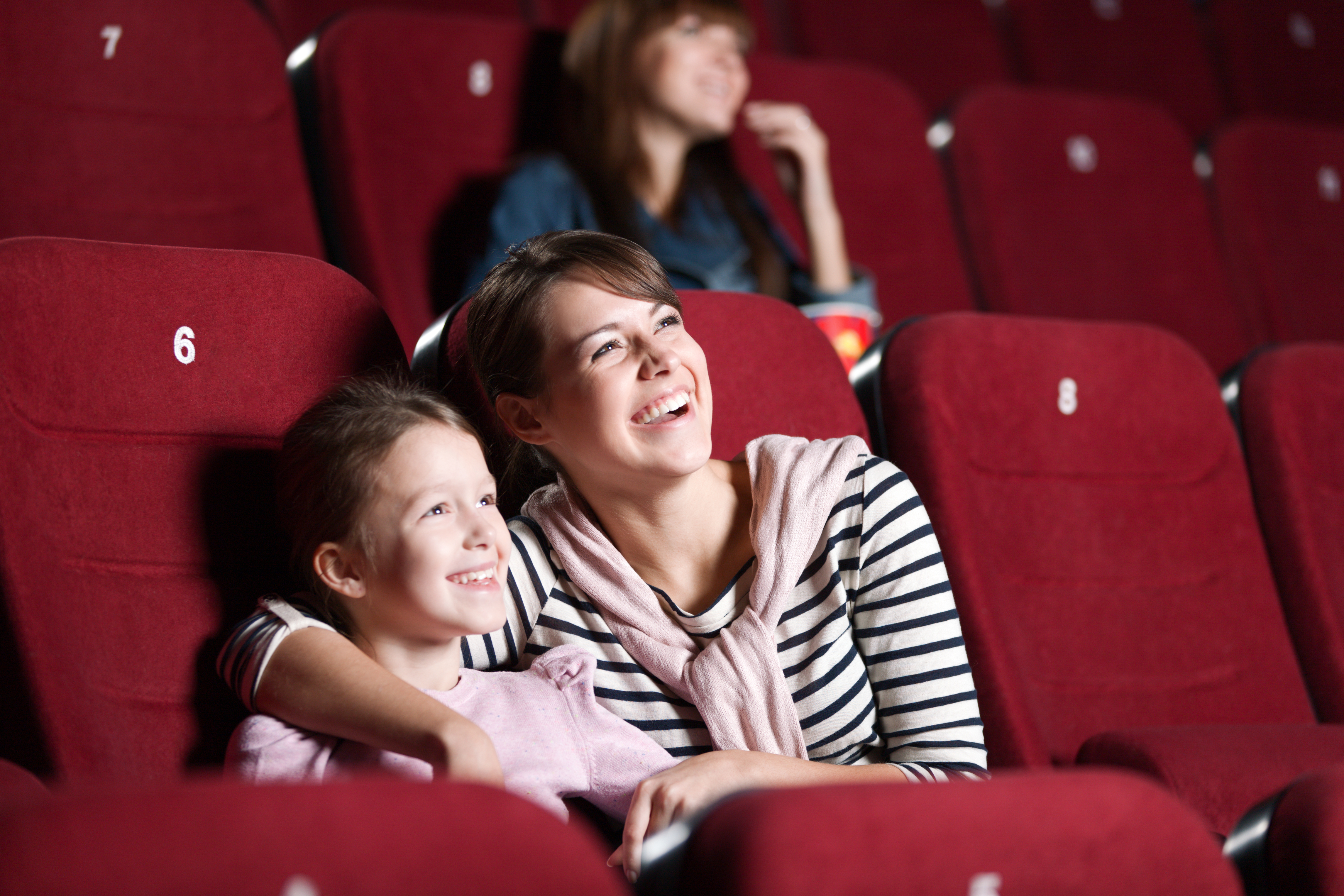 A mother and daughter having fun in a movie theater | Source: Shutterstock