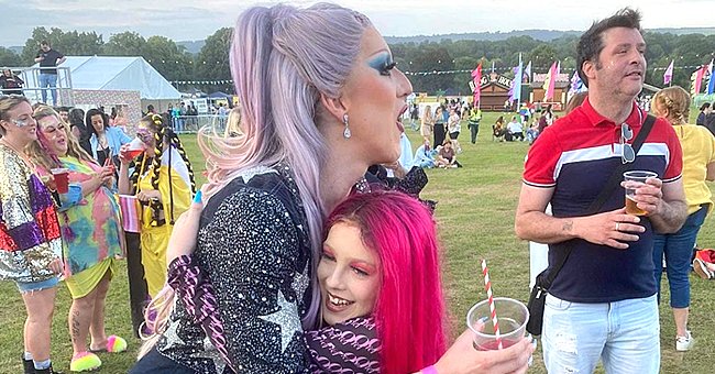 A young boy is dressed in drag and hugs another drag queen as they attend a park performance | Photo: Instagram/missoatiet