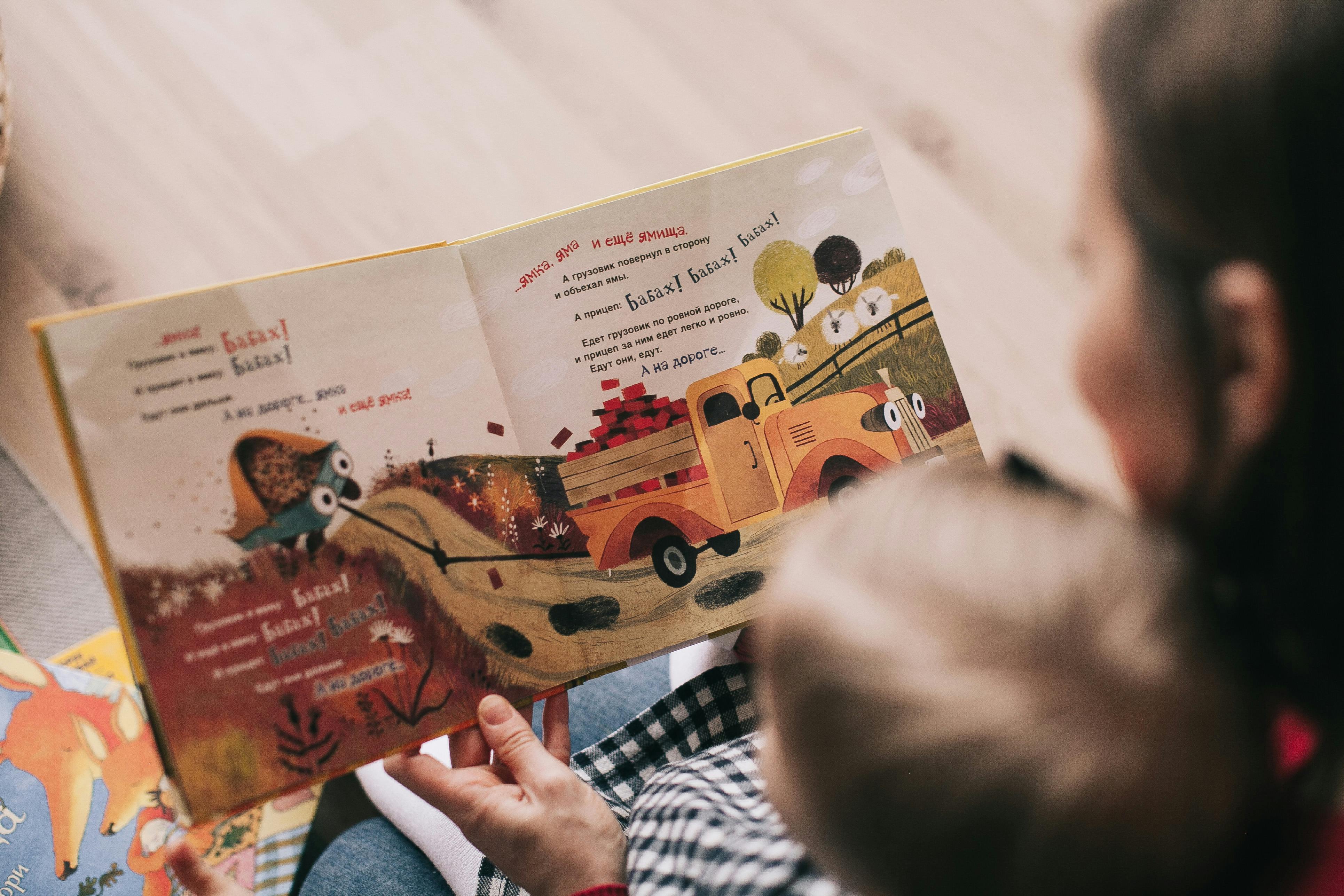 A woman reading a book to a child | Source: Pexels