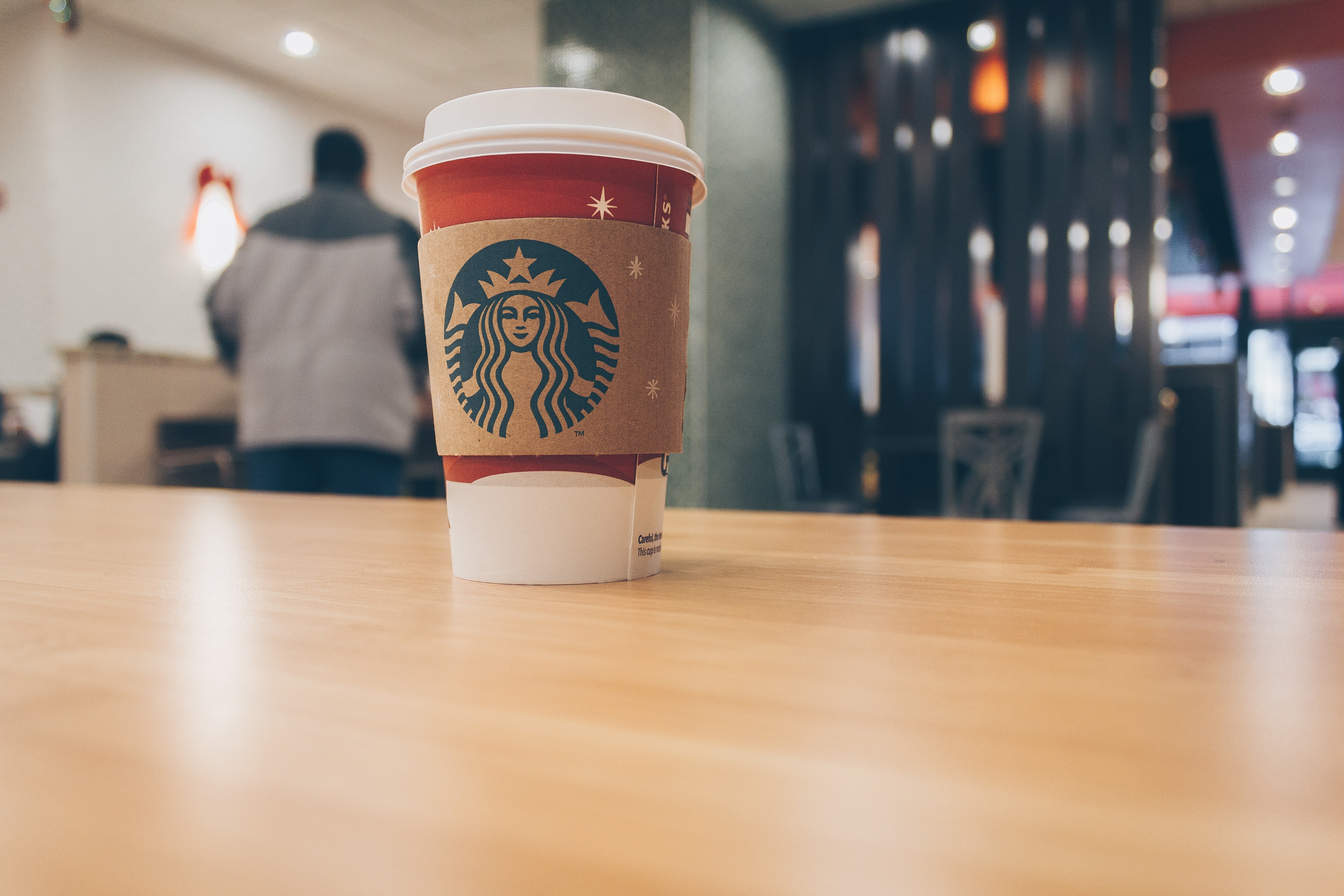 A cup of coffee from Starbucks stands on a desktop | Photo: Pexels/Josh Sorenson