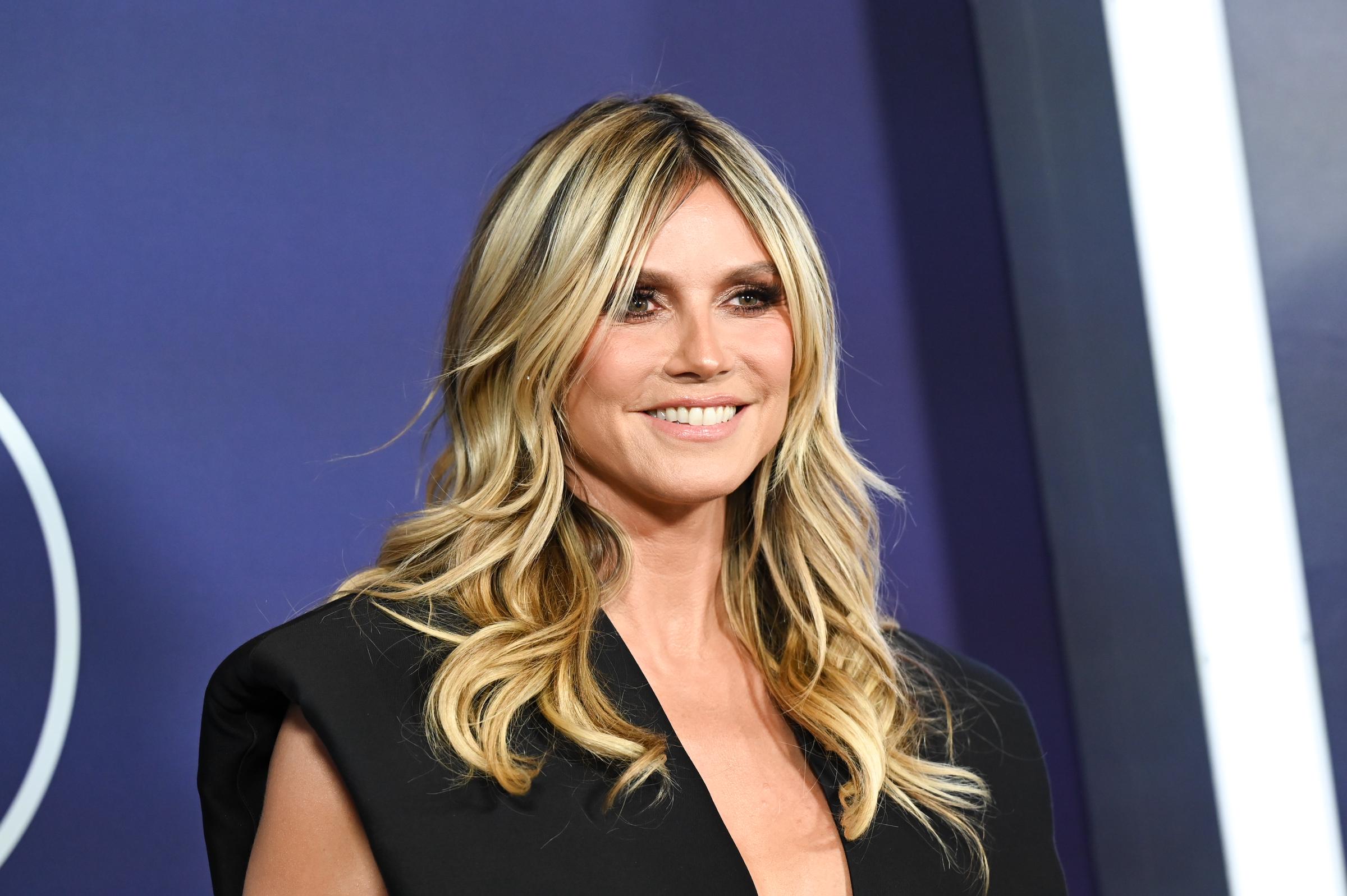 Heidi Klum flashes a bright smile on the AMAs red carpet, her soft curls framing a bronzed makeup look with smoky eyes and nude lips that kept her glam effortlessly balanced.