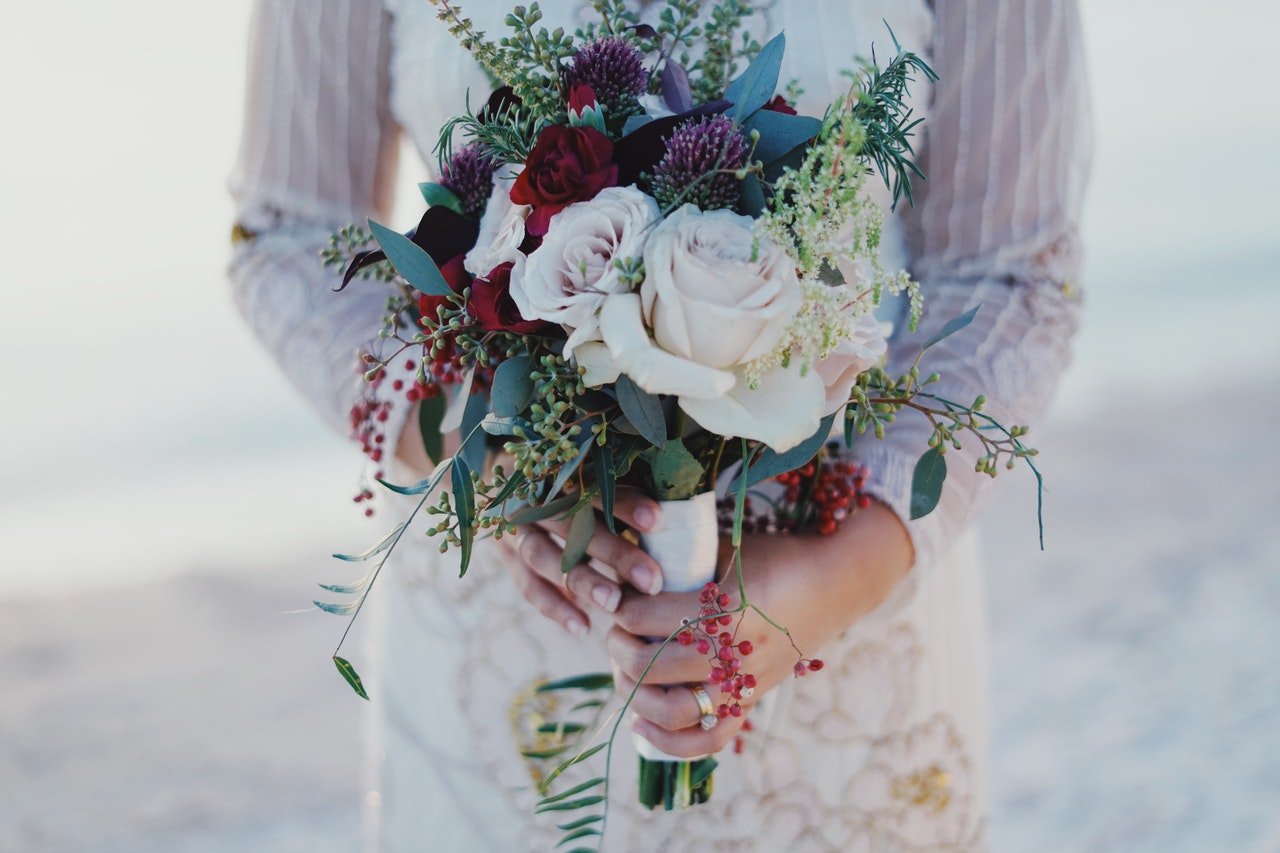 Photo of a bride holding a flower bouquet | Photo: Pexels
