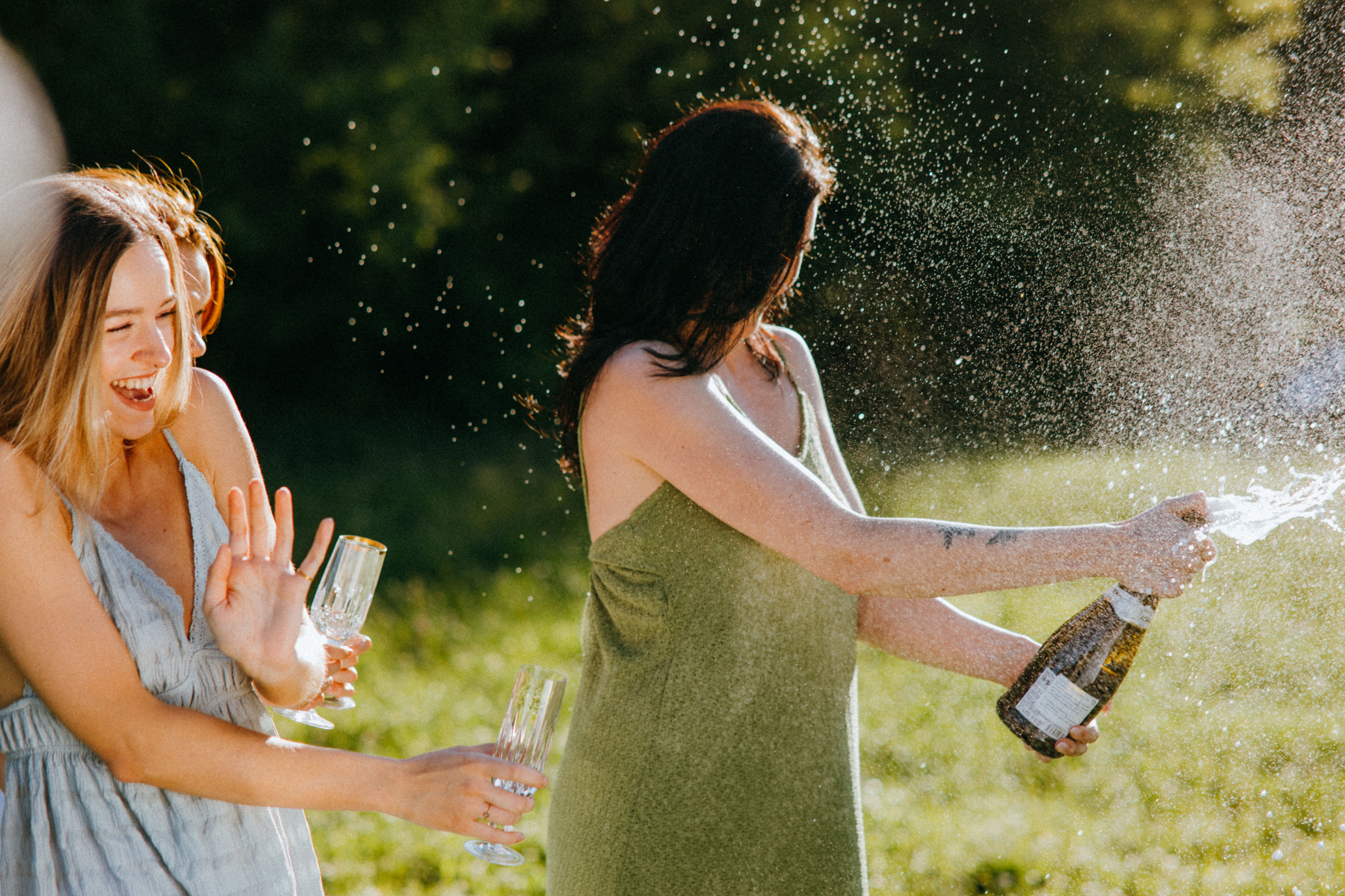 A woman popping champagne as another women reacts | Source: Pexels
