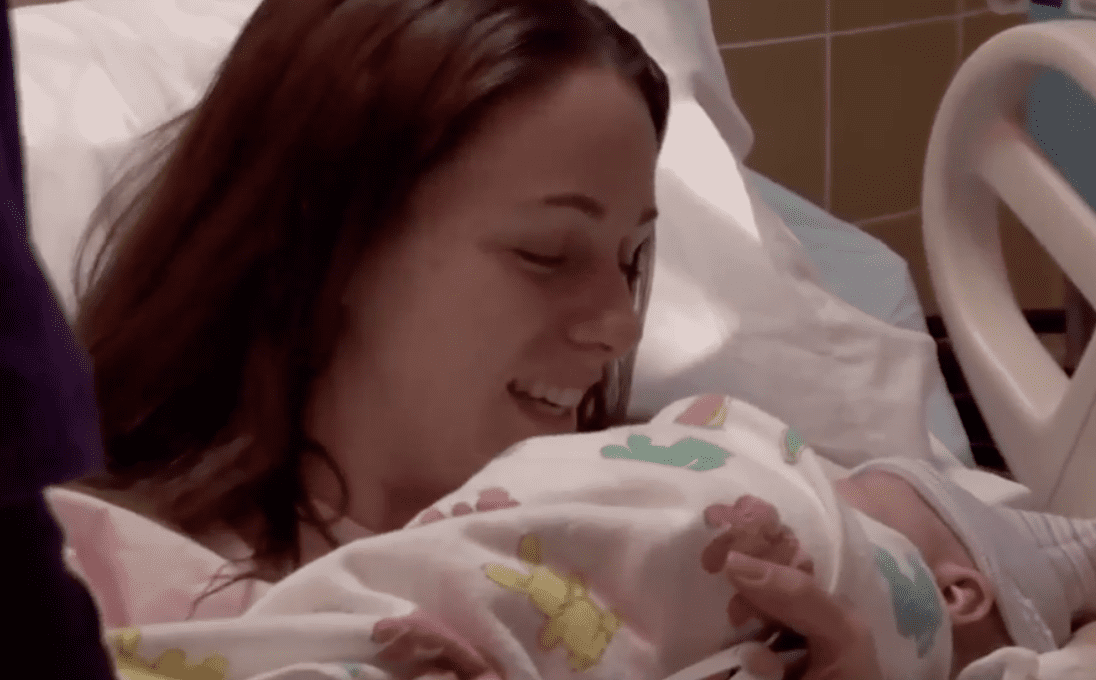 A teen that didn't know she was expecting holds her newborn for the first time | Photo: Youtube/tlc uk