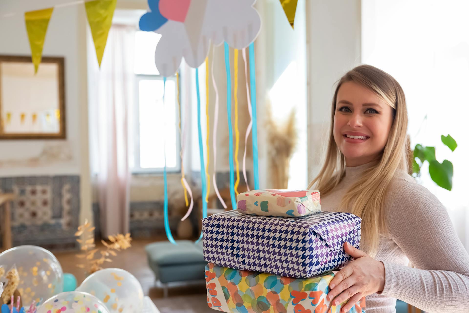 A woman holding a stack of gifts during a baby shower | Source: Pexels