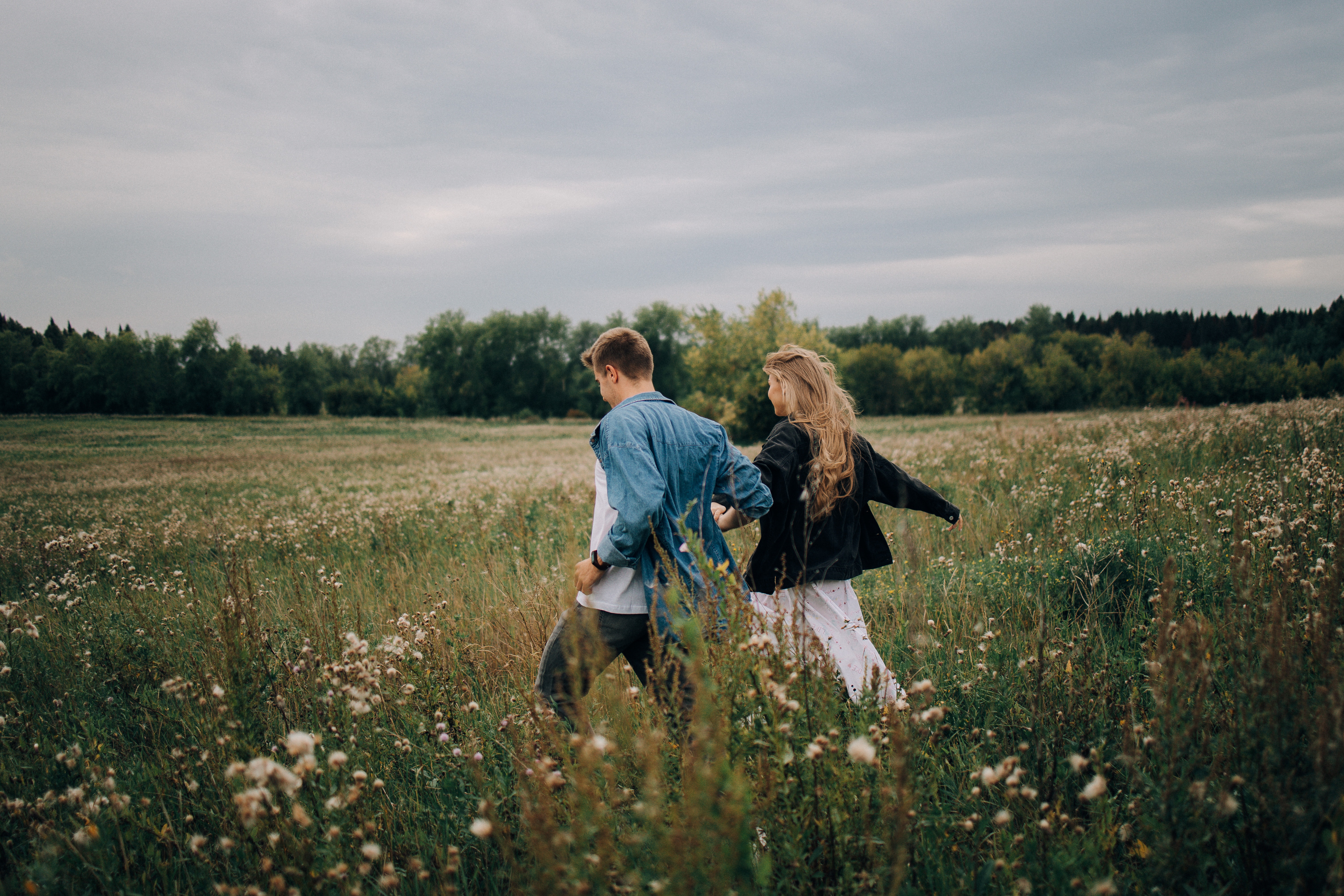 Couple running through a field | Source: Pexels