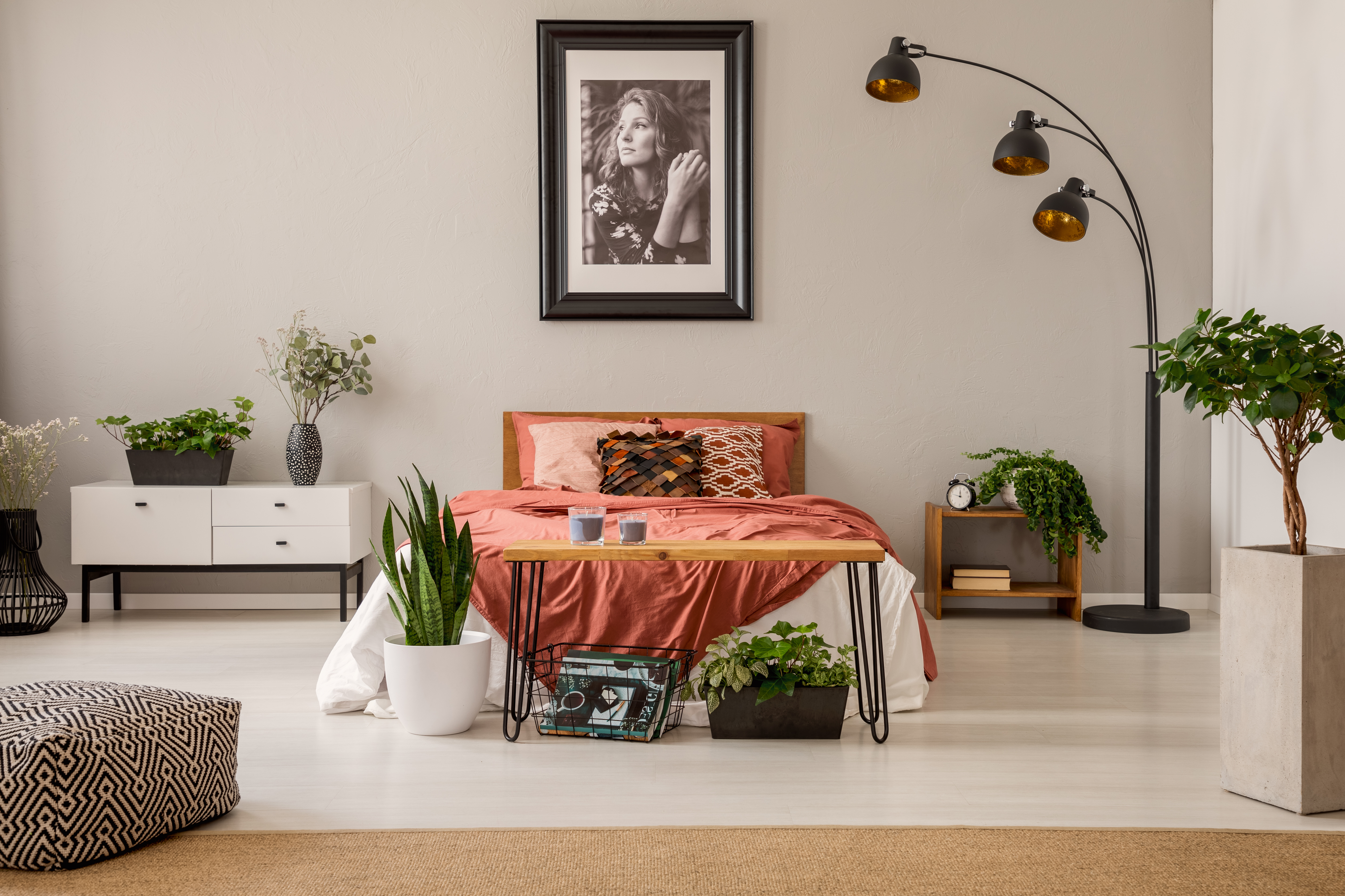 A cozy bedroom with a photo of a woman hanging above the bed | Source: Shutterstock