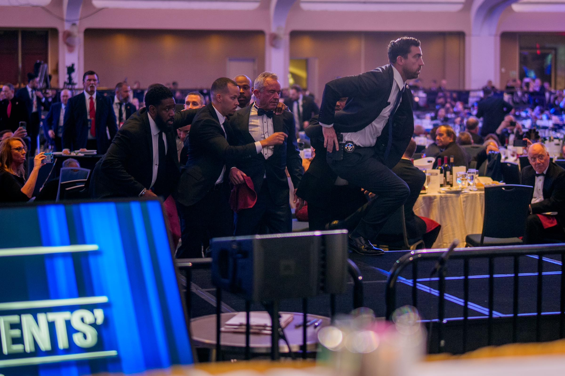 Health and Human Services Secretary Robert F. Kennedy Jr. (C) is taken out of the ballroom by security agents during a shooting incident at the annual White House Correspondents Association Dinner at the Washington Hilton on April 25, 2026 in Washington, DC | Source: Getty Images