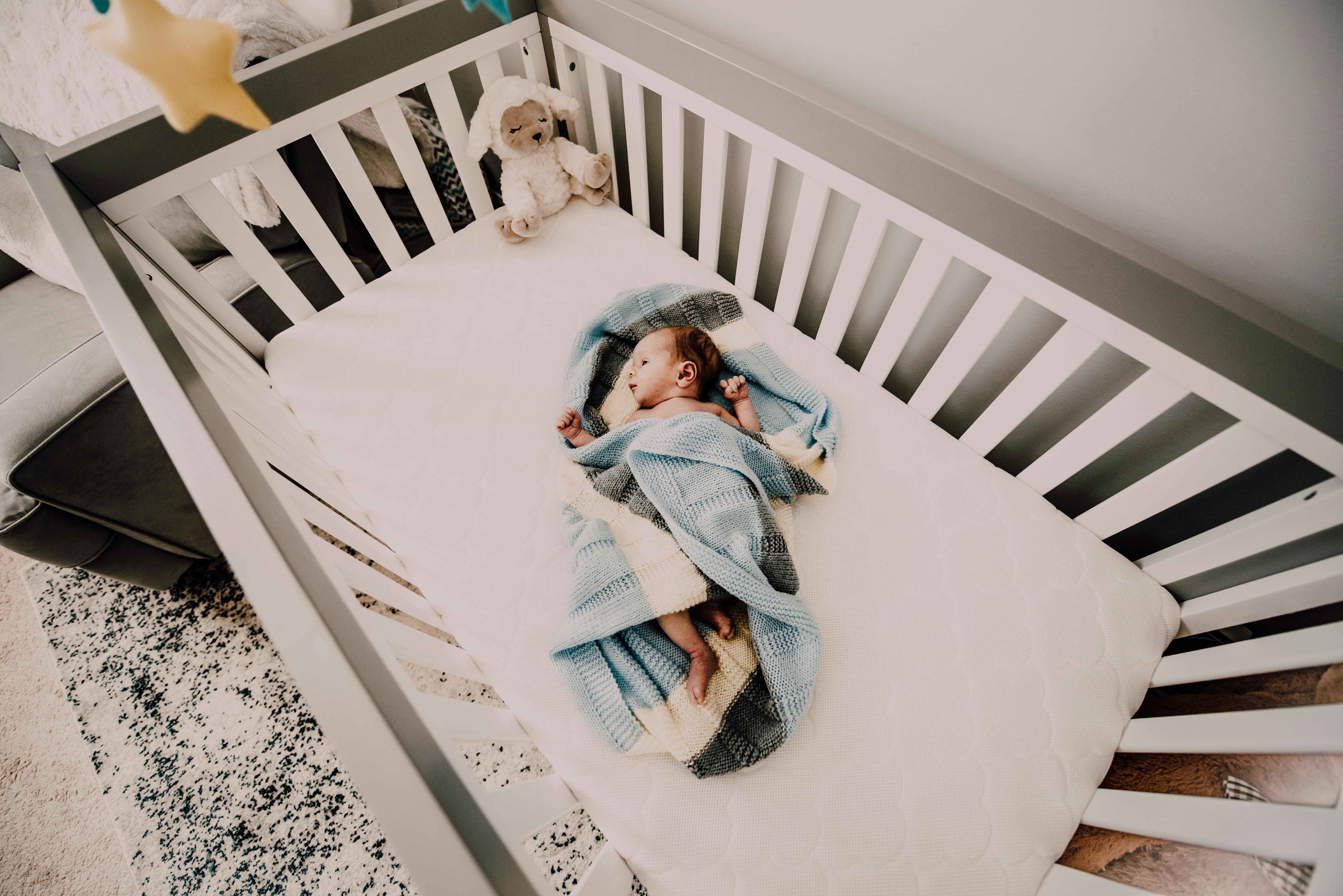 A baby sleeping in a playpen | Source: Pexels