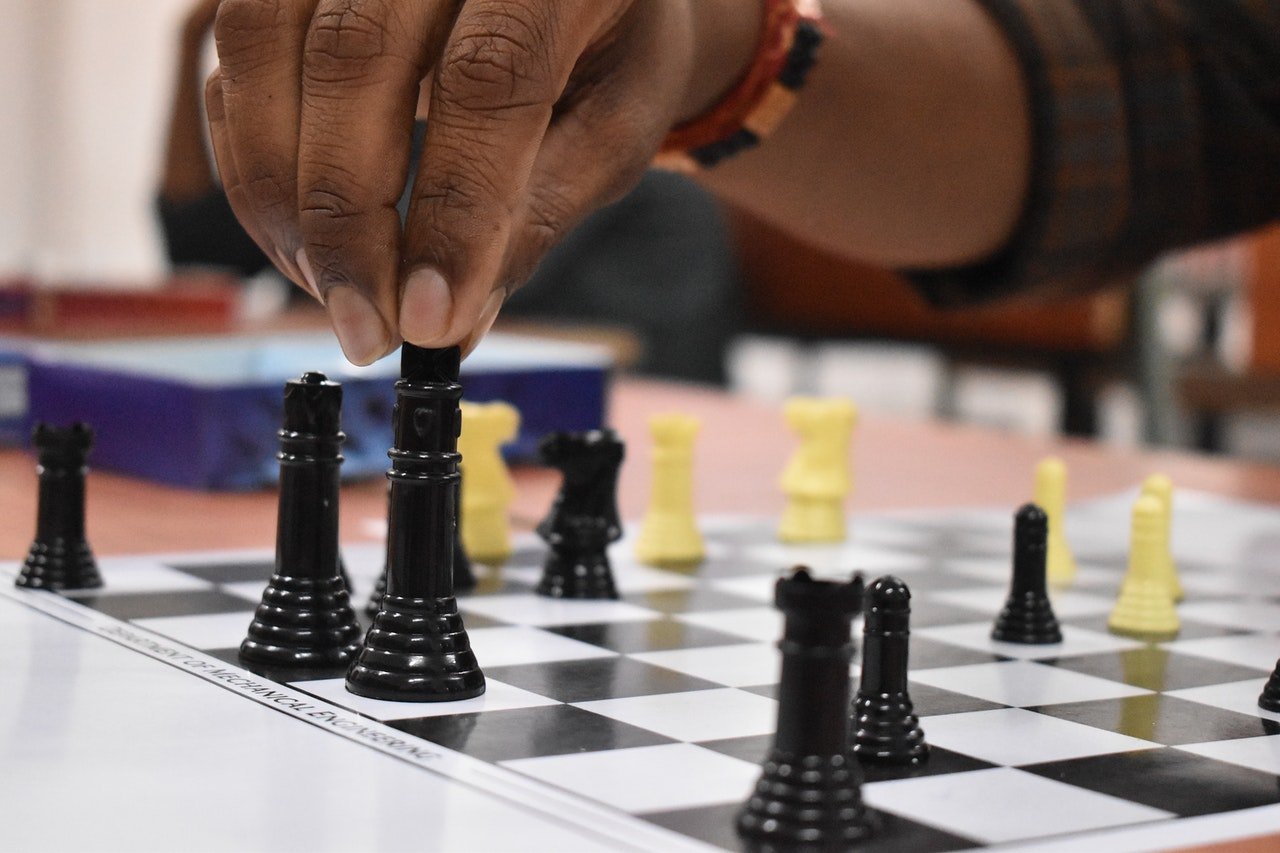 Hand holding a chess piece | Photo: Pexels