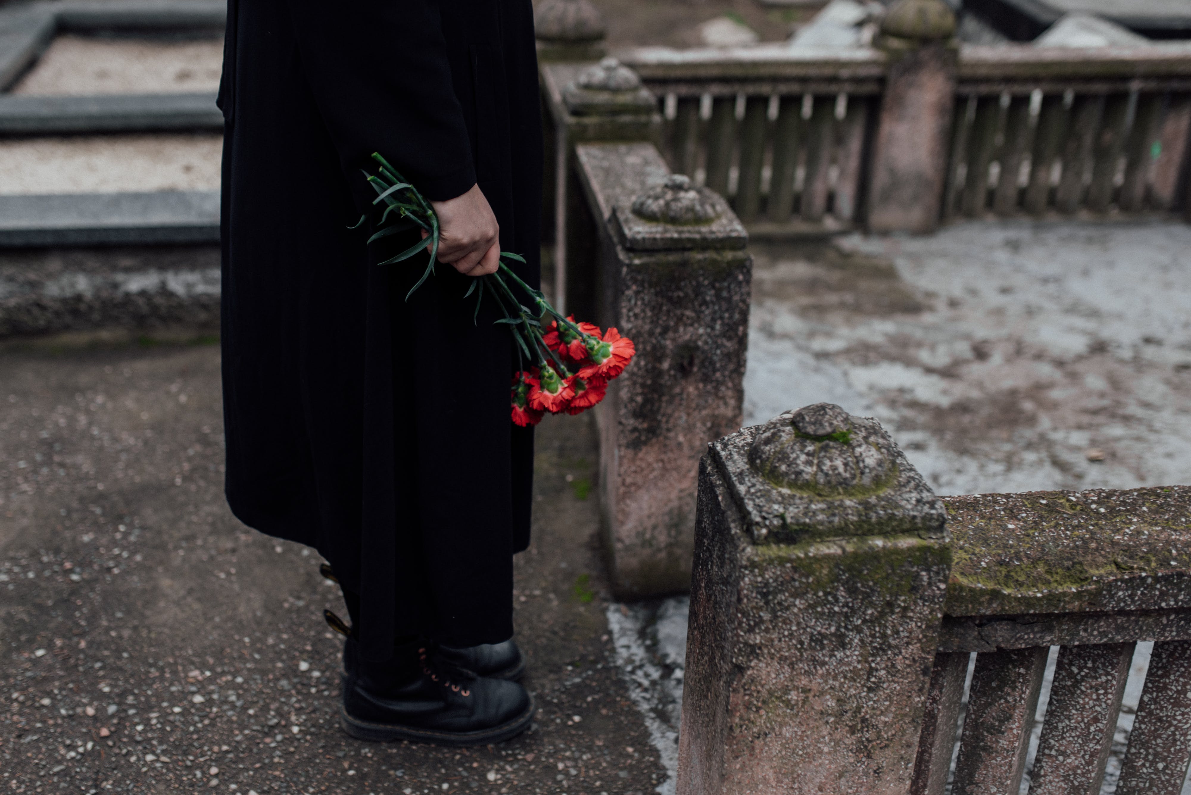 A Person Holding Red Roses at a Cemetery. | Source: Pexels