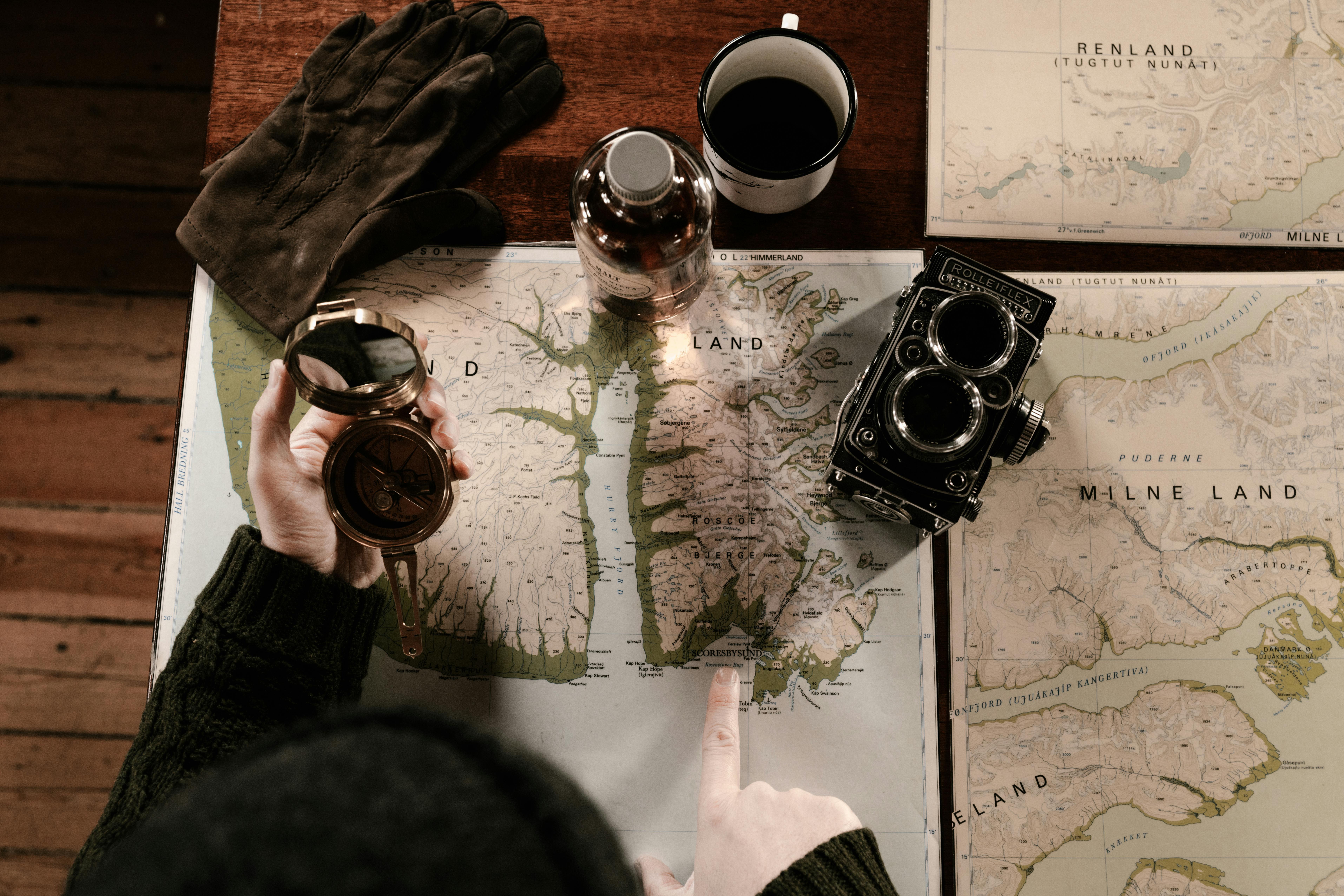 Map, compass, and camera on the table | Source: Pexels