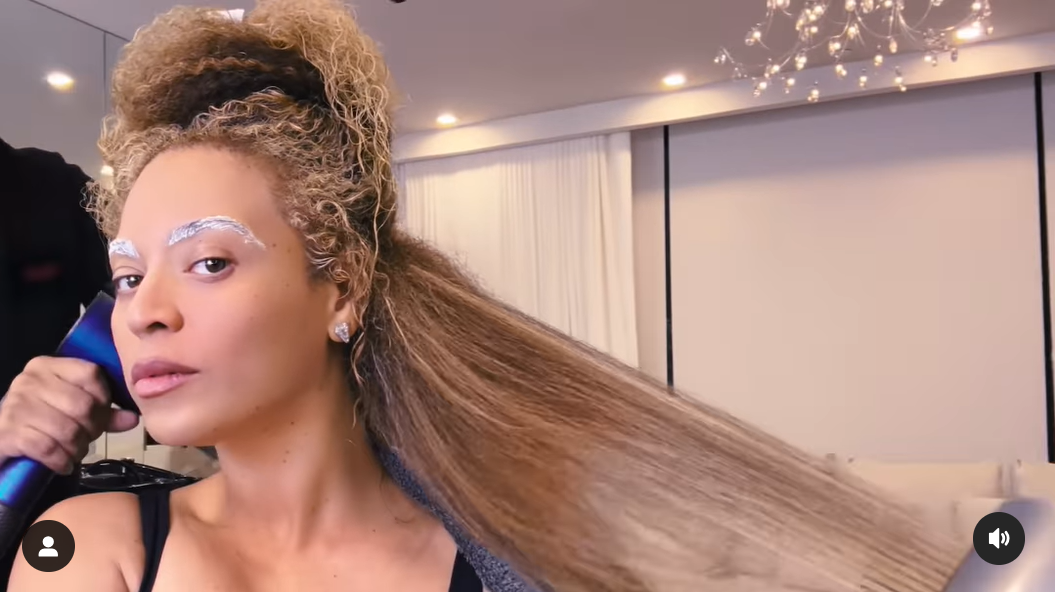 Beyoncé helping to iron her blonde hair in a video shared in April 2024. | Source: Instagram/beyonce