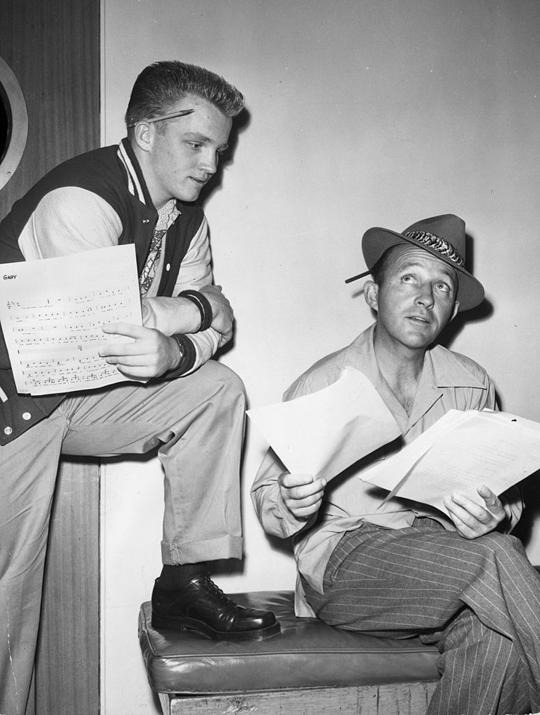 Gary and Bing Crosby pictured having a discussion over a musical arrangement for one his father's show in January 1950. | Photo: Getty Images