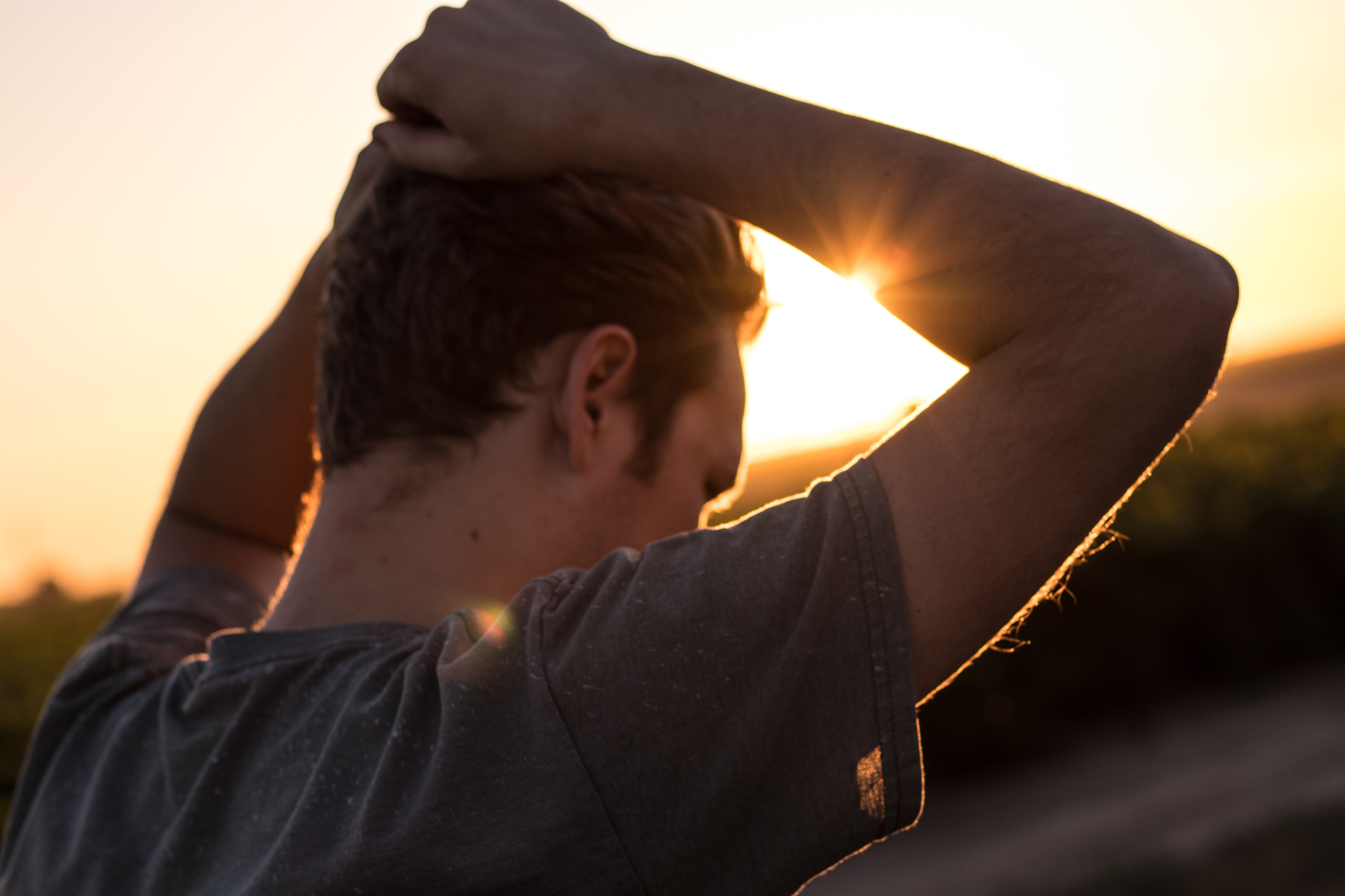 A stressed out man standing outside with his hands over his head | Source: Unsplash