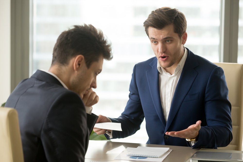 An angry mean boss yelling at an employee. | Photo: Shutterstock.