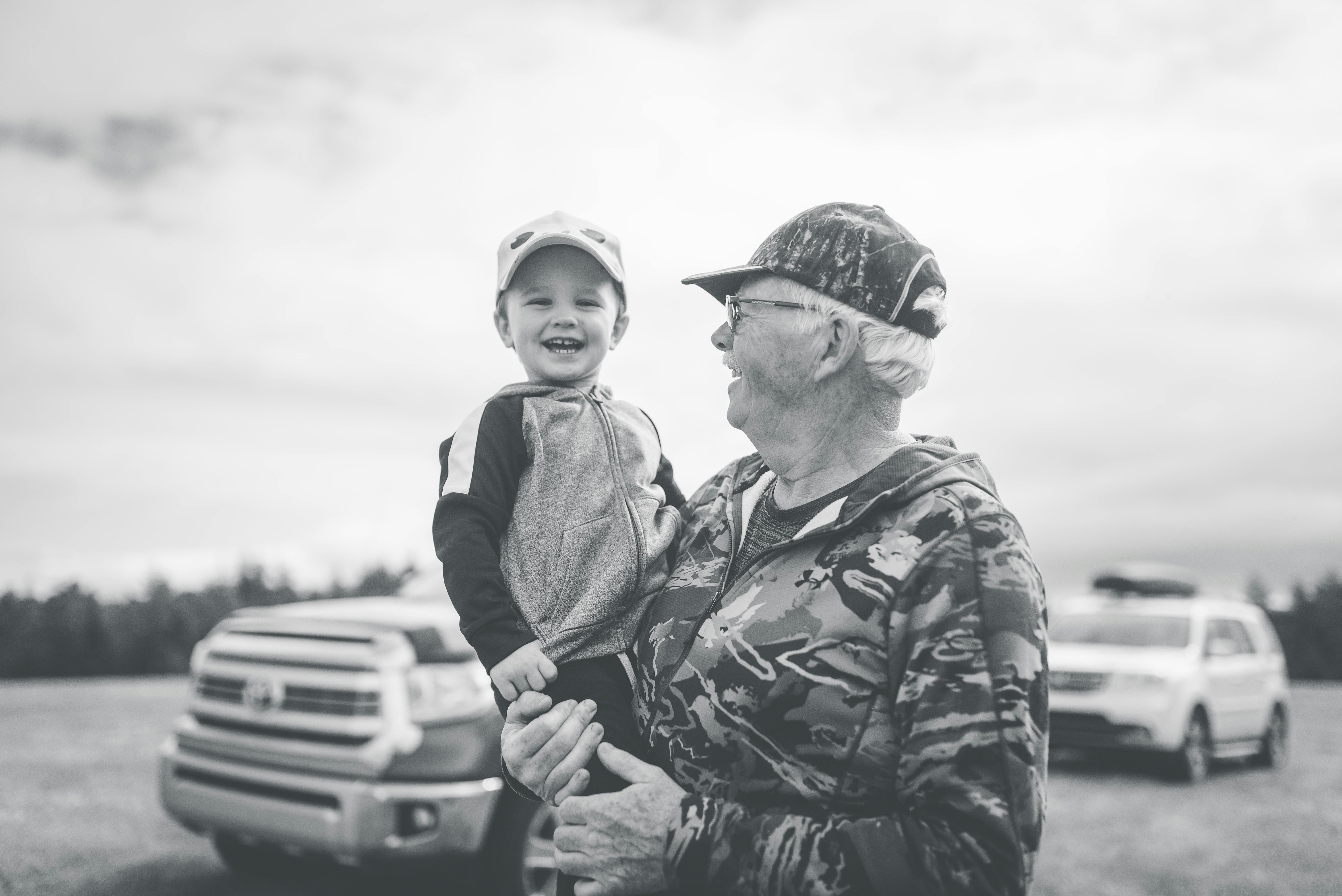 A happy old man holding a child in his arms | Source: Pexels