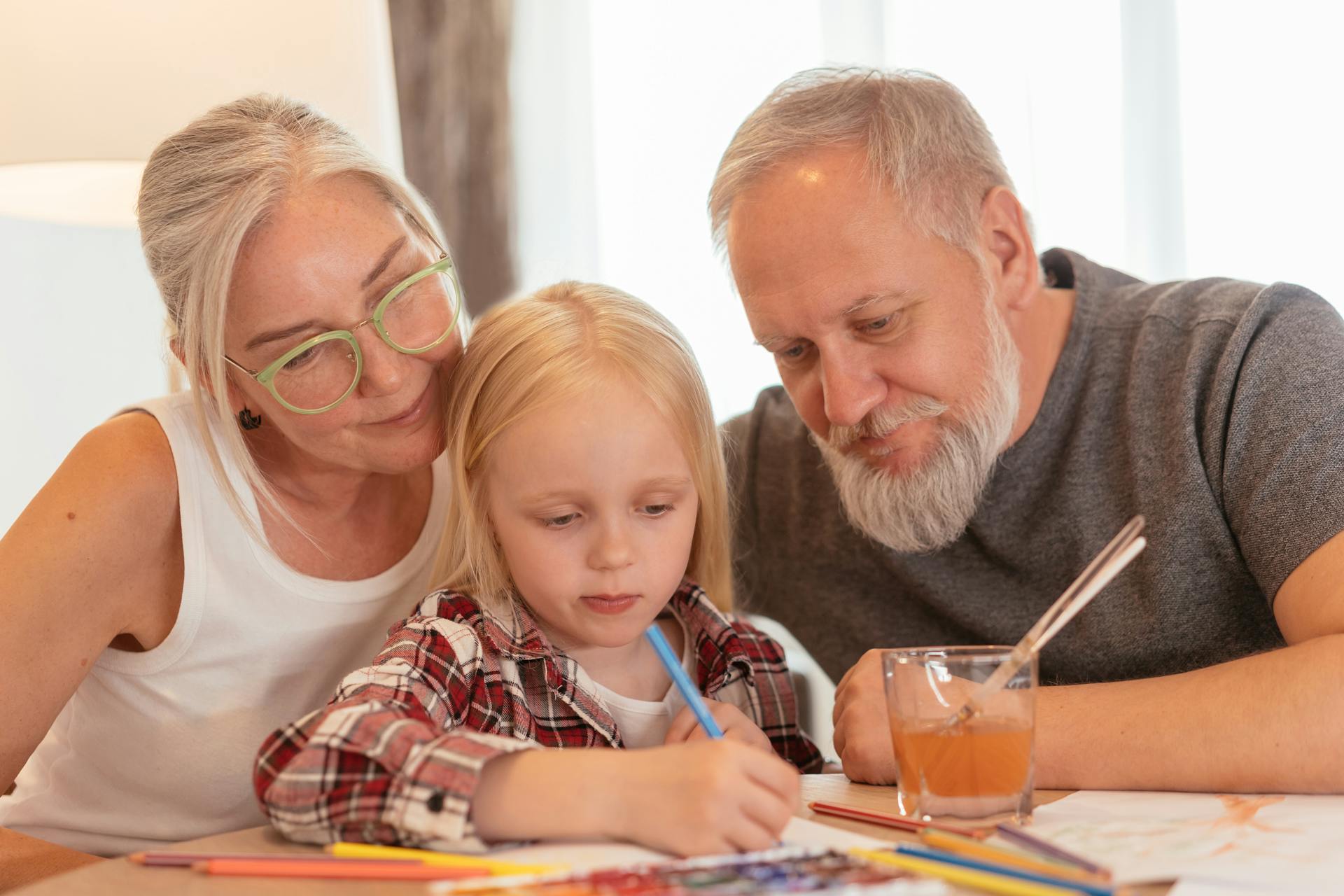 Una niña coloreando con sus abuelos | Fuente: Pexels