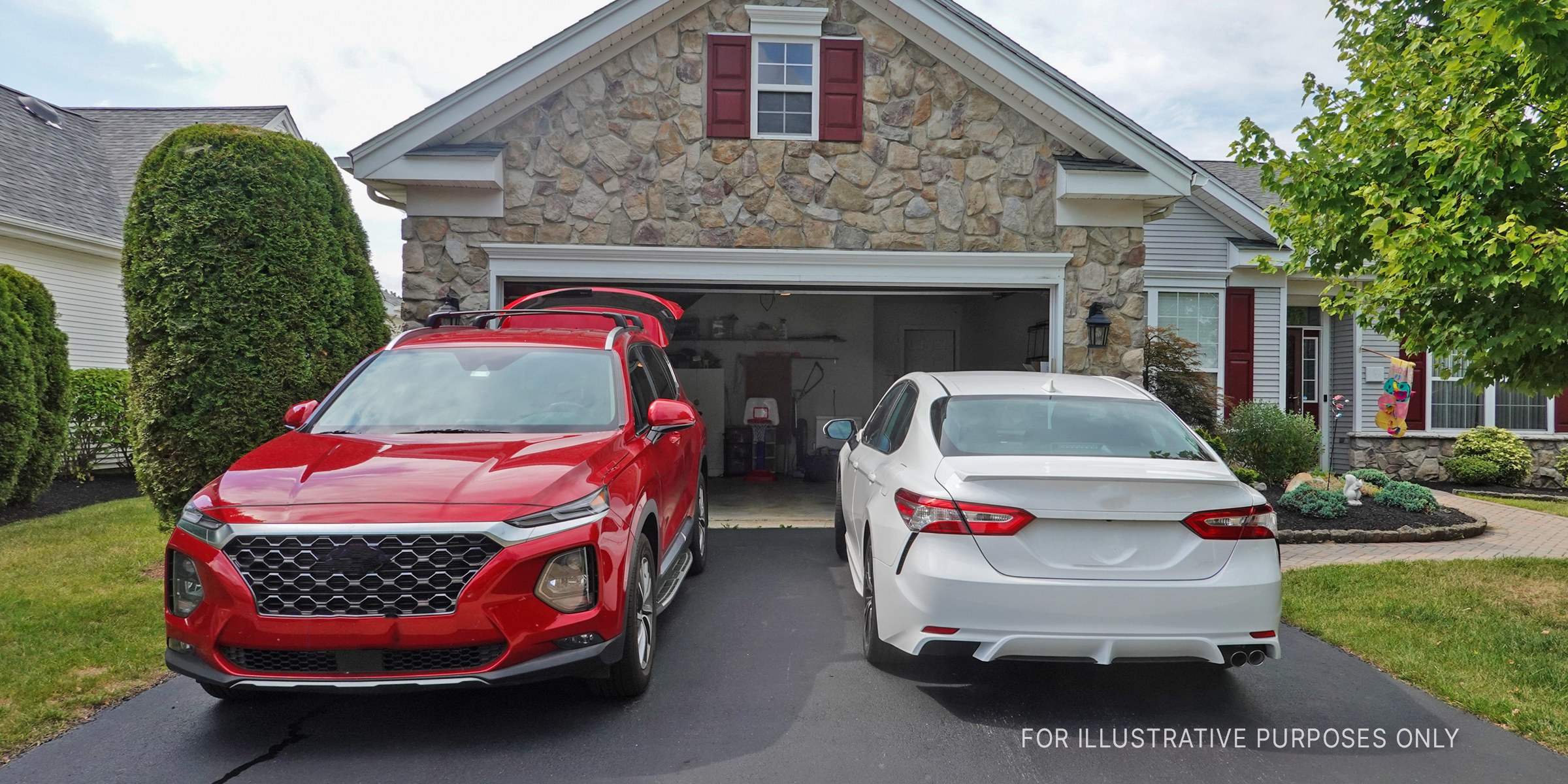 A red SUV and a white sedan parked in a driveway | Source: Shutterstock