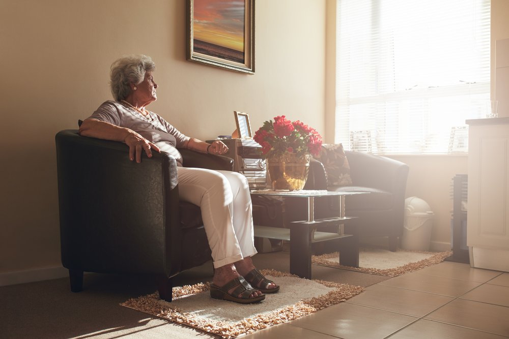 Anciana sentada sola en un sofá. | Foto: Shutterstock