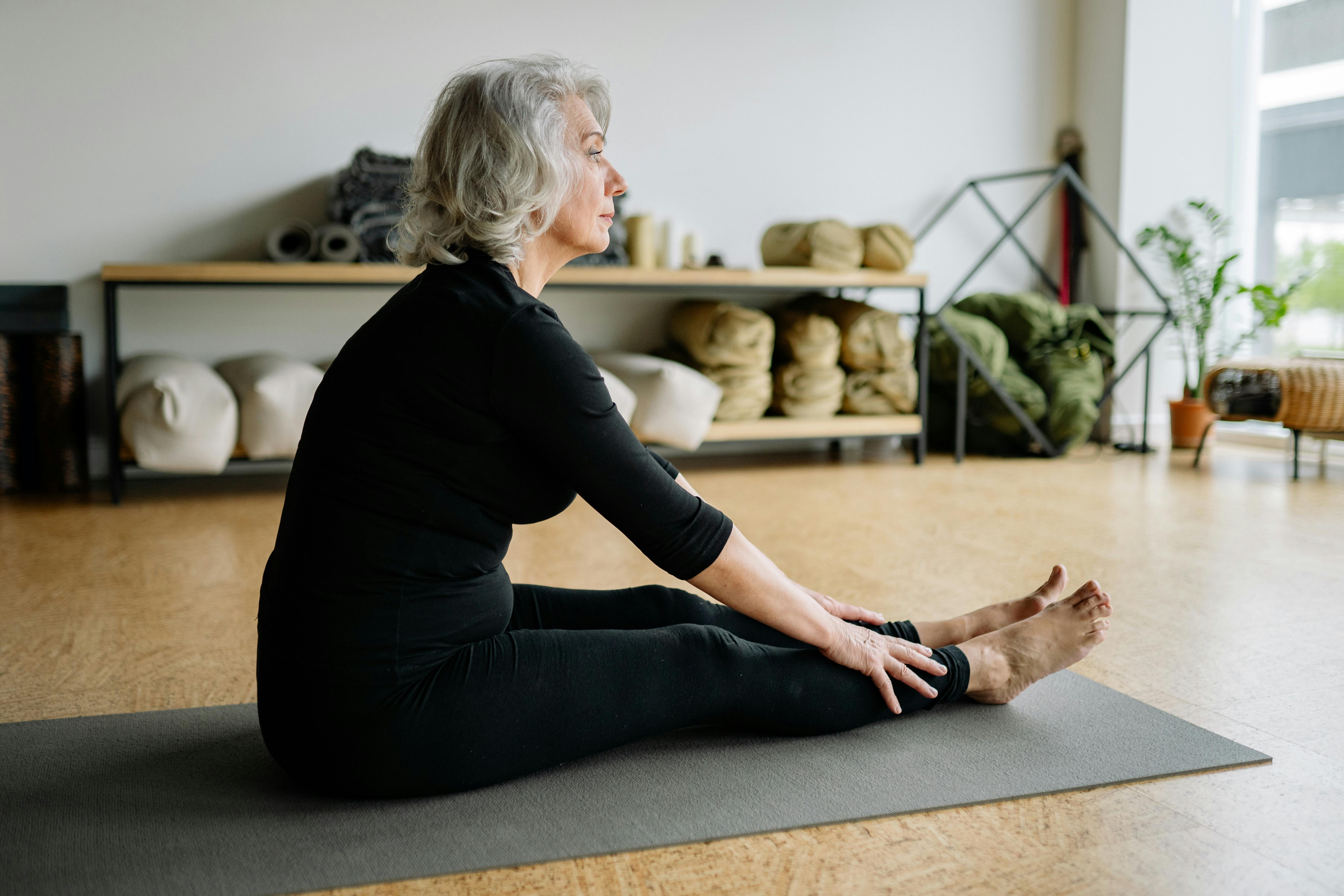 A woman sitting on a yoga mat | Source: Pexels