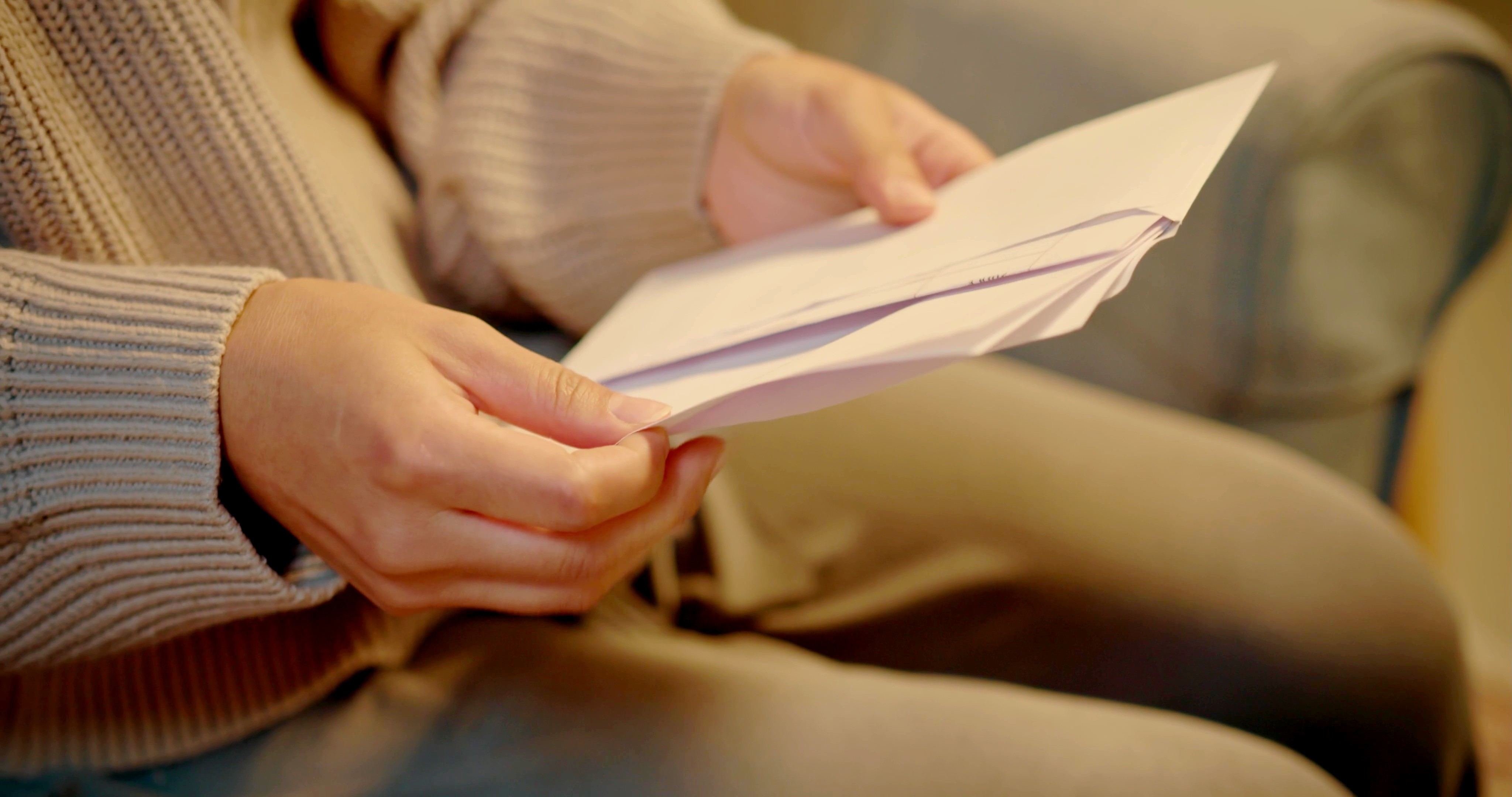 A woman opening an envelope | Source: Shutterstock