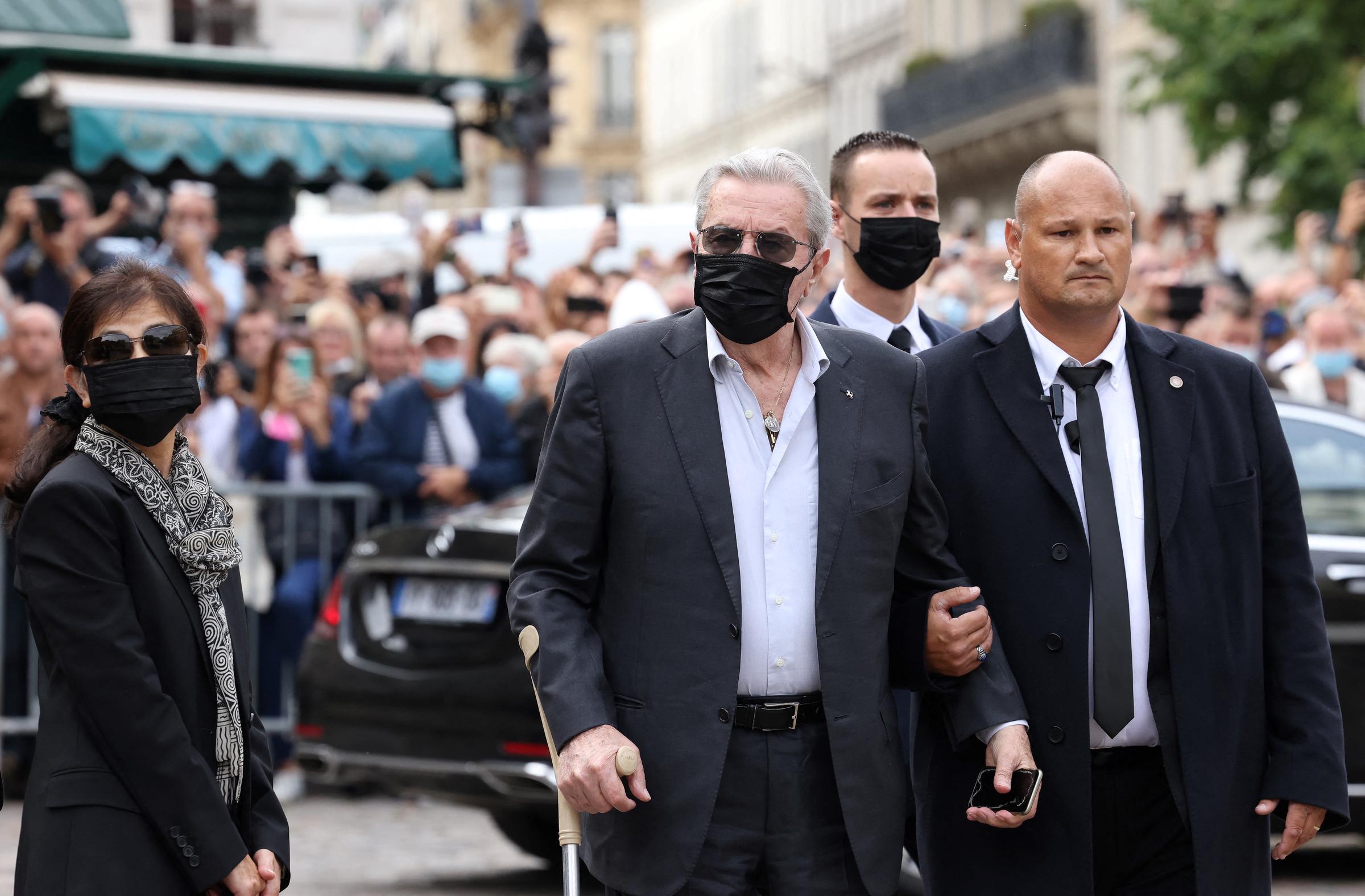 Alain Delon (C) arrives with his partner and assistant Hiromi Rollin (L) for the funeral ceremony for late French actor Jean-Paul Belmondo in Paris on September 10, 2021 | Source: Getty Images