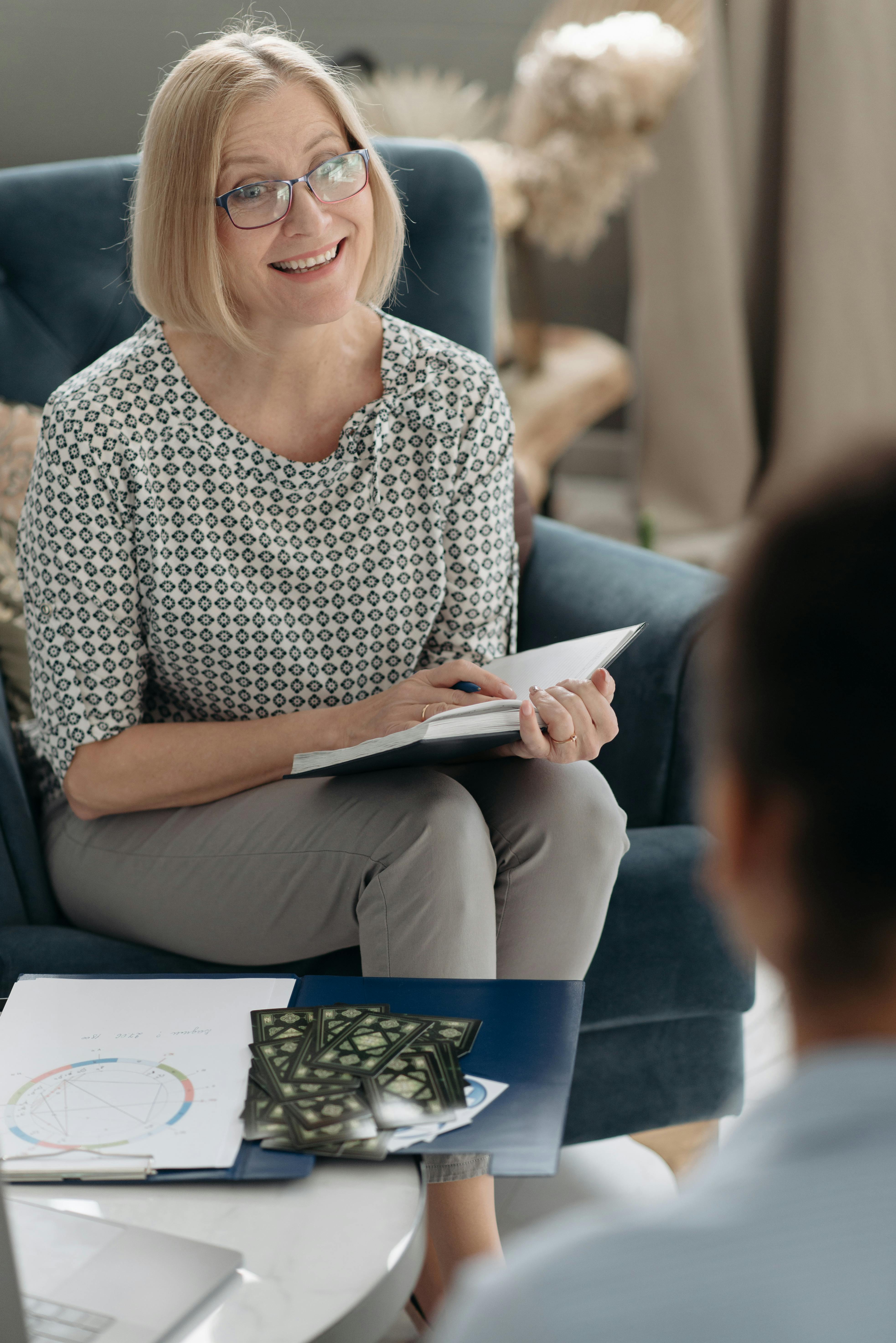 A woman holding a book while talking to someone | Source: Pexels