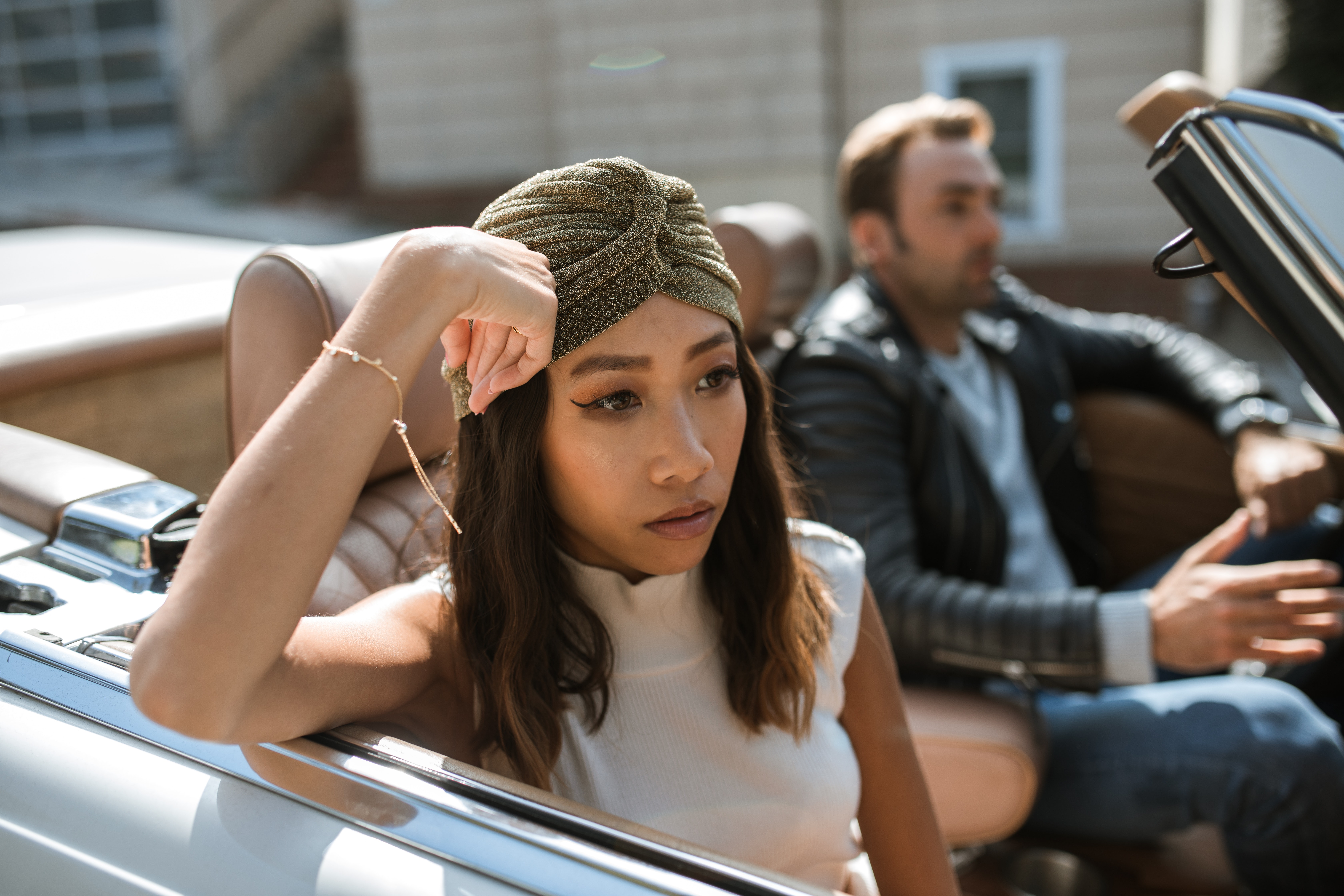 Woman in white tank top sitting in a car feeling annoyed. | Source: Pexels