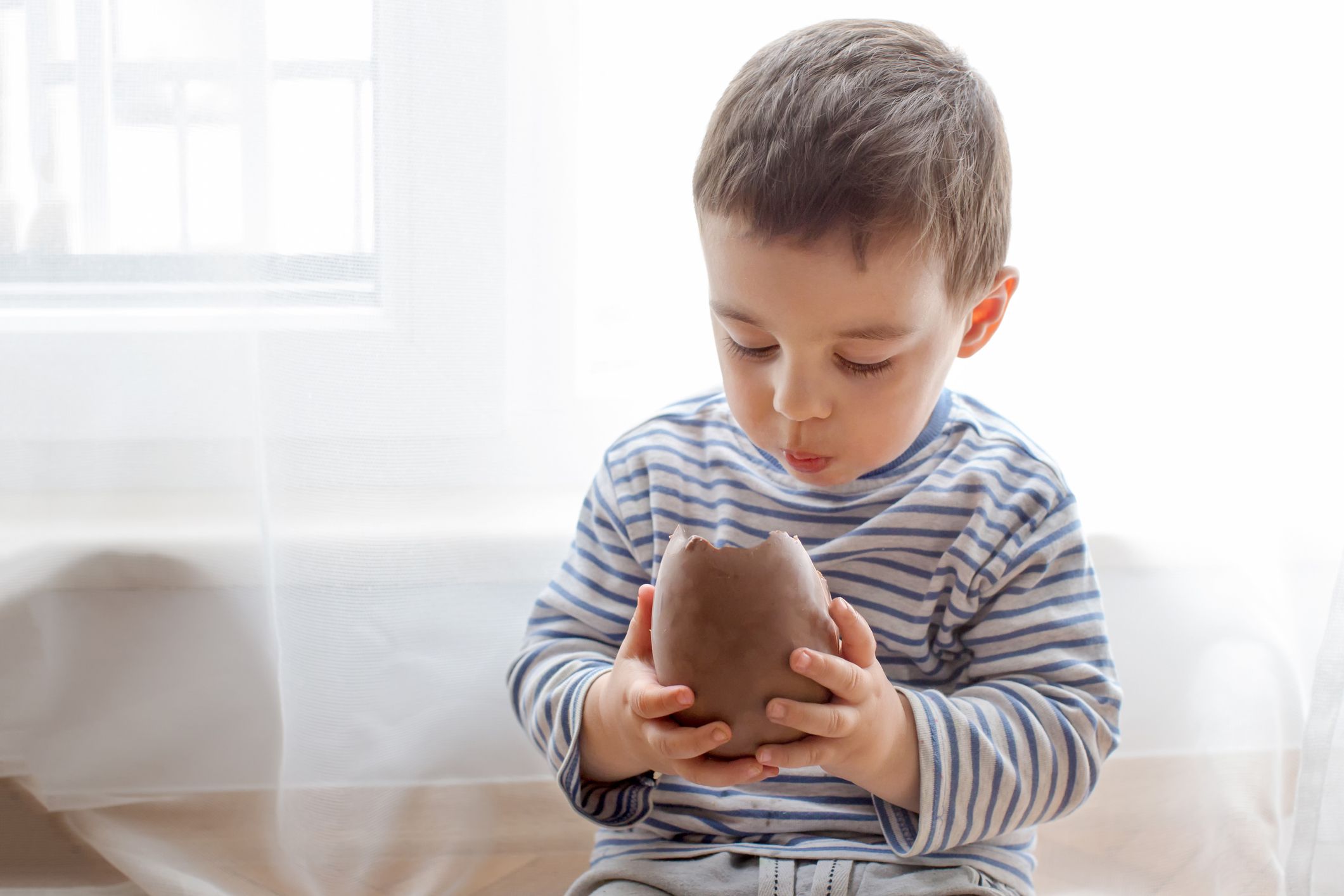 Ein Junge isst ein großes Schoko-Osterei. | Quelle: GettyImages