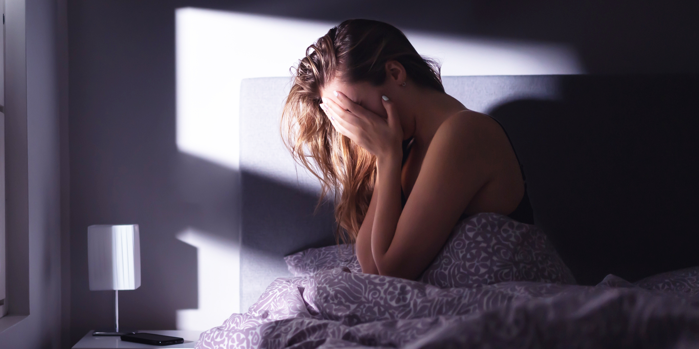 A Woman Is Pictured Crying in Bed | Source: Shutterstock