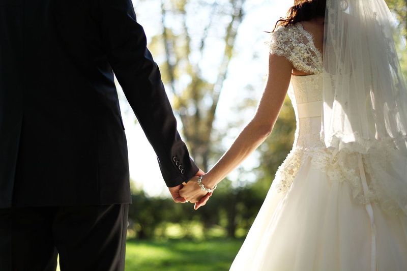 A bride and groom holding hands. | Source: Shutterstock