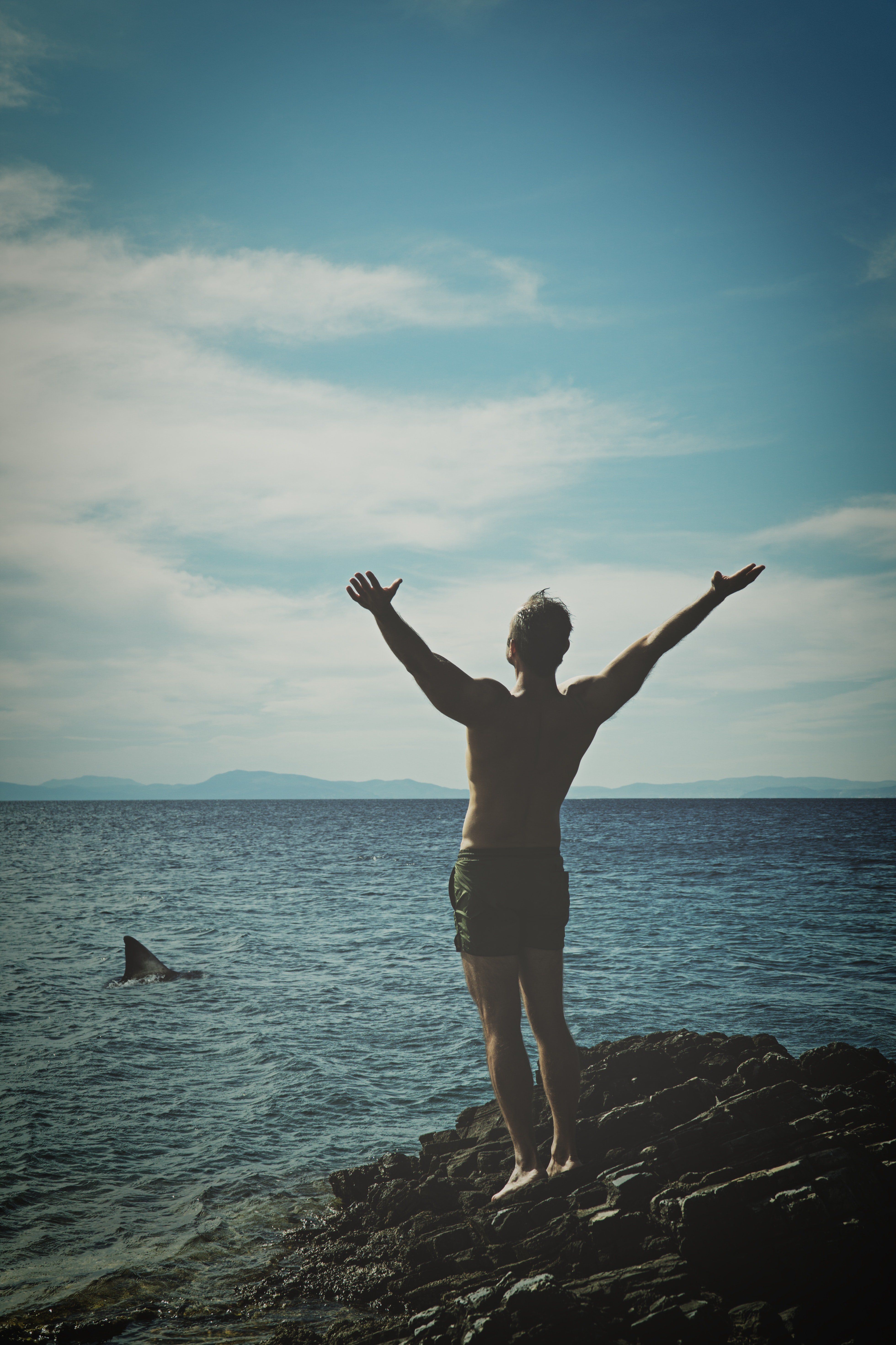 A man standing on the rock near an ocean | Photo: Pexels