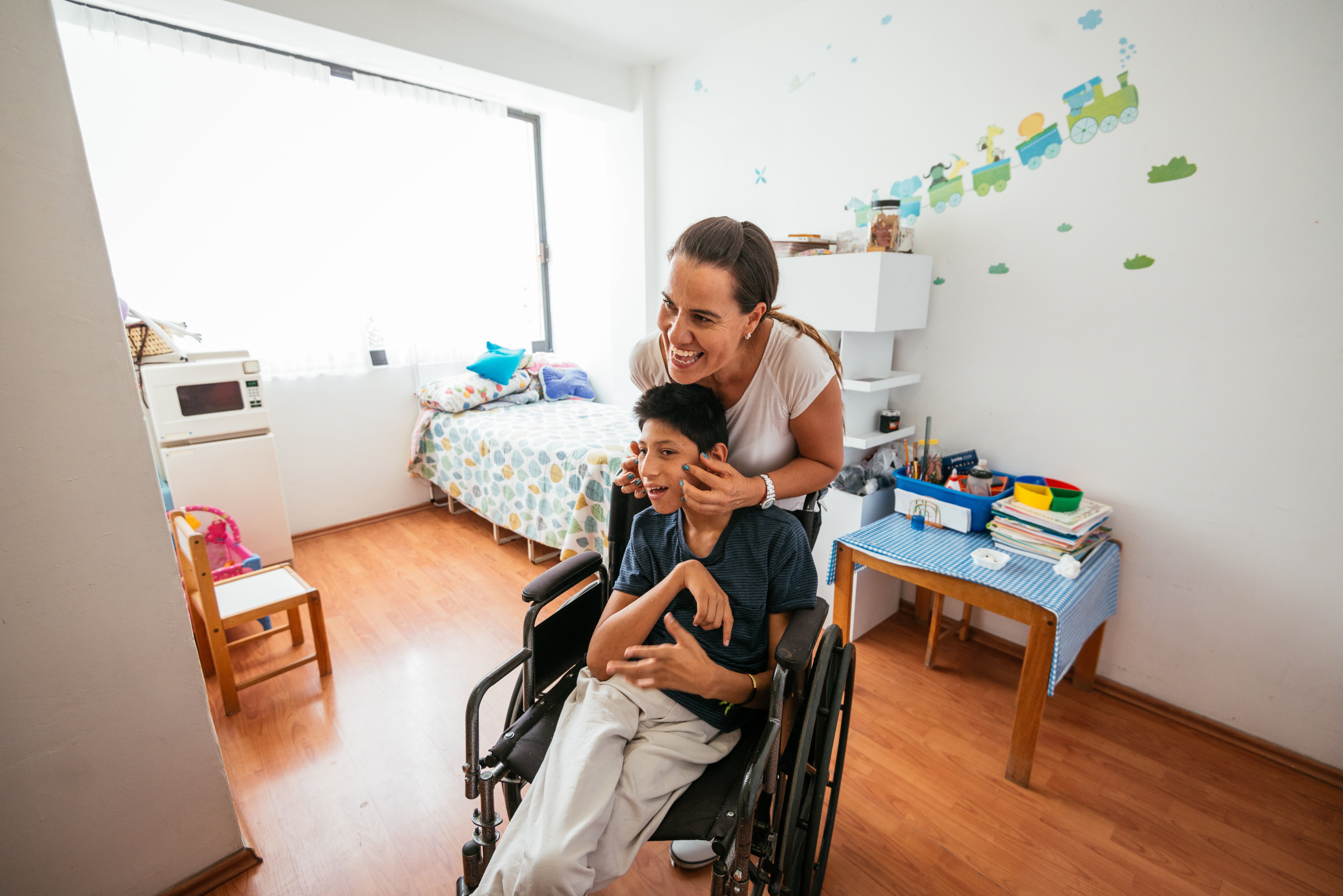 Latina mother massaging her son with Celebral Palsy|Photo: Getty Images
