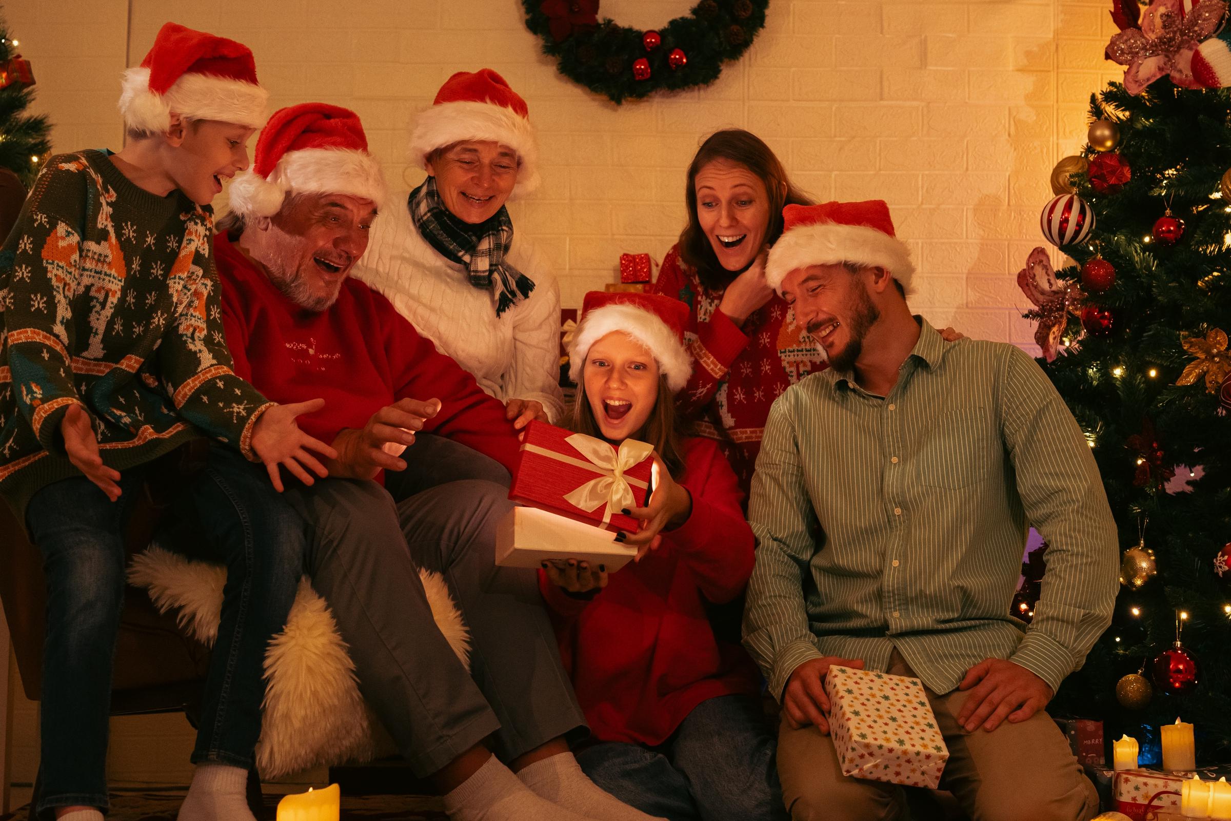 A family wearing Santa hats during Christmas gift-giving | Source: Shutterstock