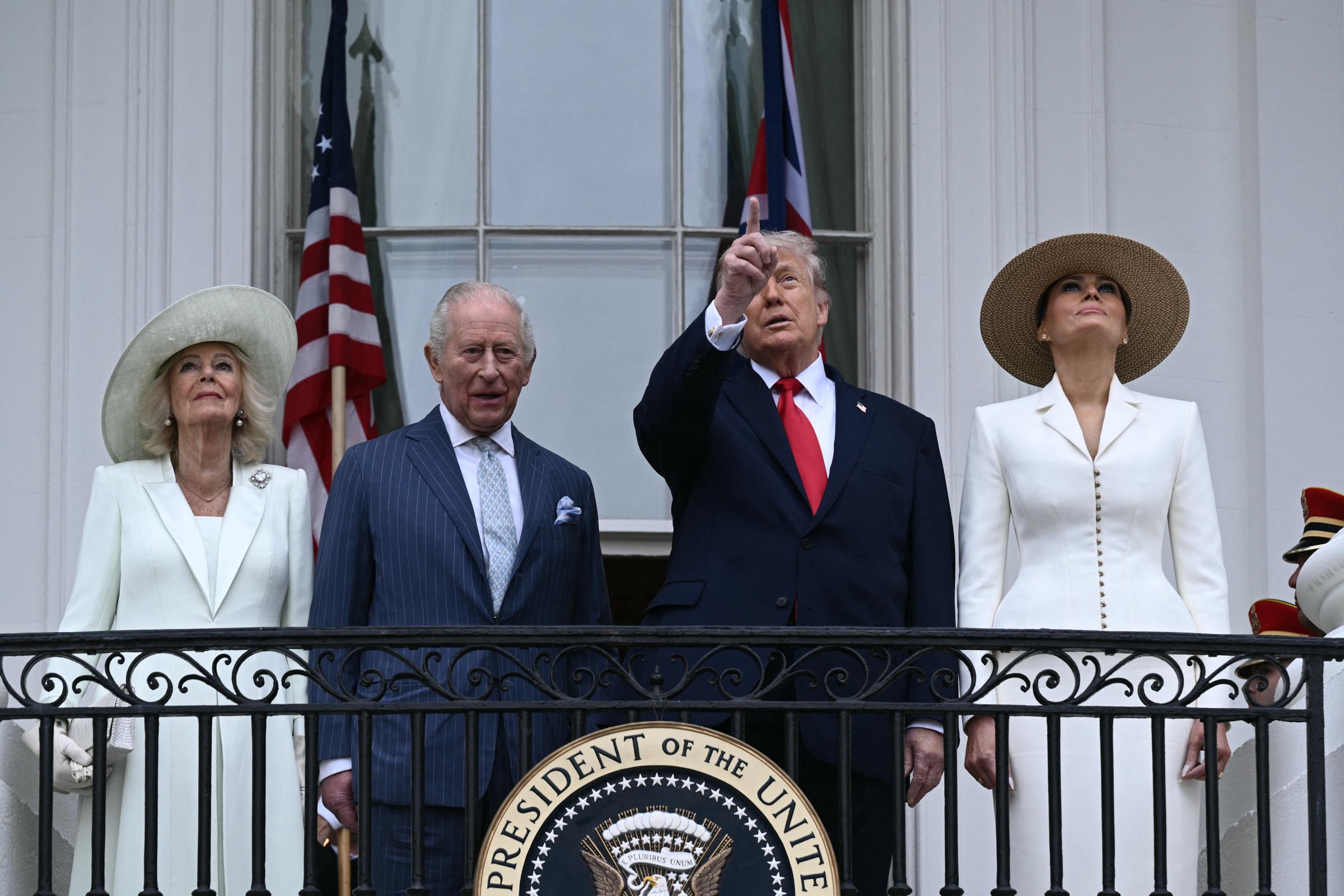 Donald Trump points upward as Melania Trump and Queen Camilla look on with King Charles III on the White House balcony on the White House South Lawn, April 28, 2026. | Source: Getty Images