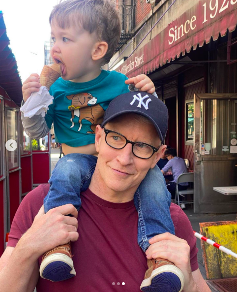 Wyatt Maisani-Cooper sitting on his dad's shoulders while eating ice cream, posted on June 19, 2022. | Source: Instagram/andersoncooper