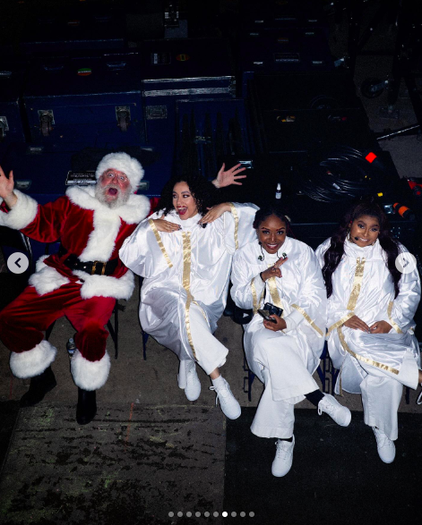 Santa Claus posing for a photo with Mariah Carey's backup singers. | Source: Instagram/mariahcarey