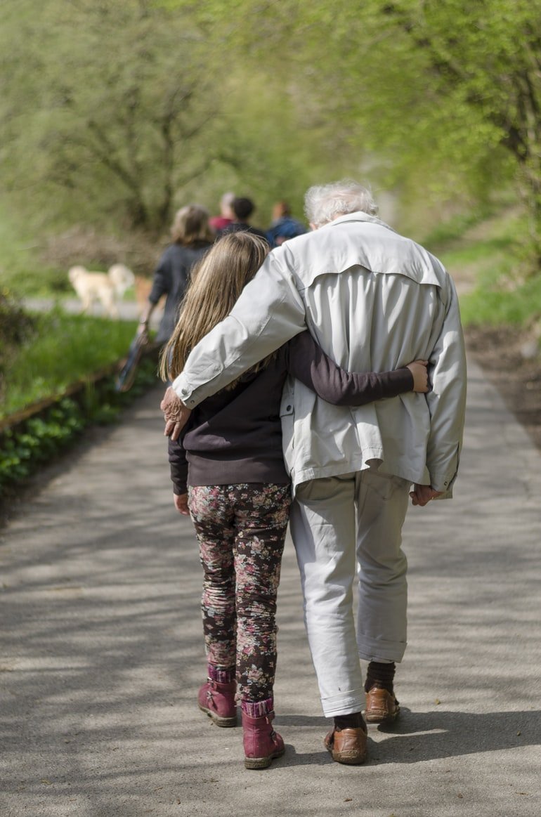 Ein junges Mädchen geht mit einem älteren Mann spazieren. | Quelle: Unsplash
