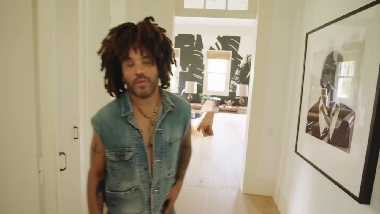 Lenny walks down a hallway decorated with a framed black-and-white portrait of his grandfather, Albert Roker, which leads directly into the master suite. | Source: YouTube/@Archdigest