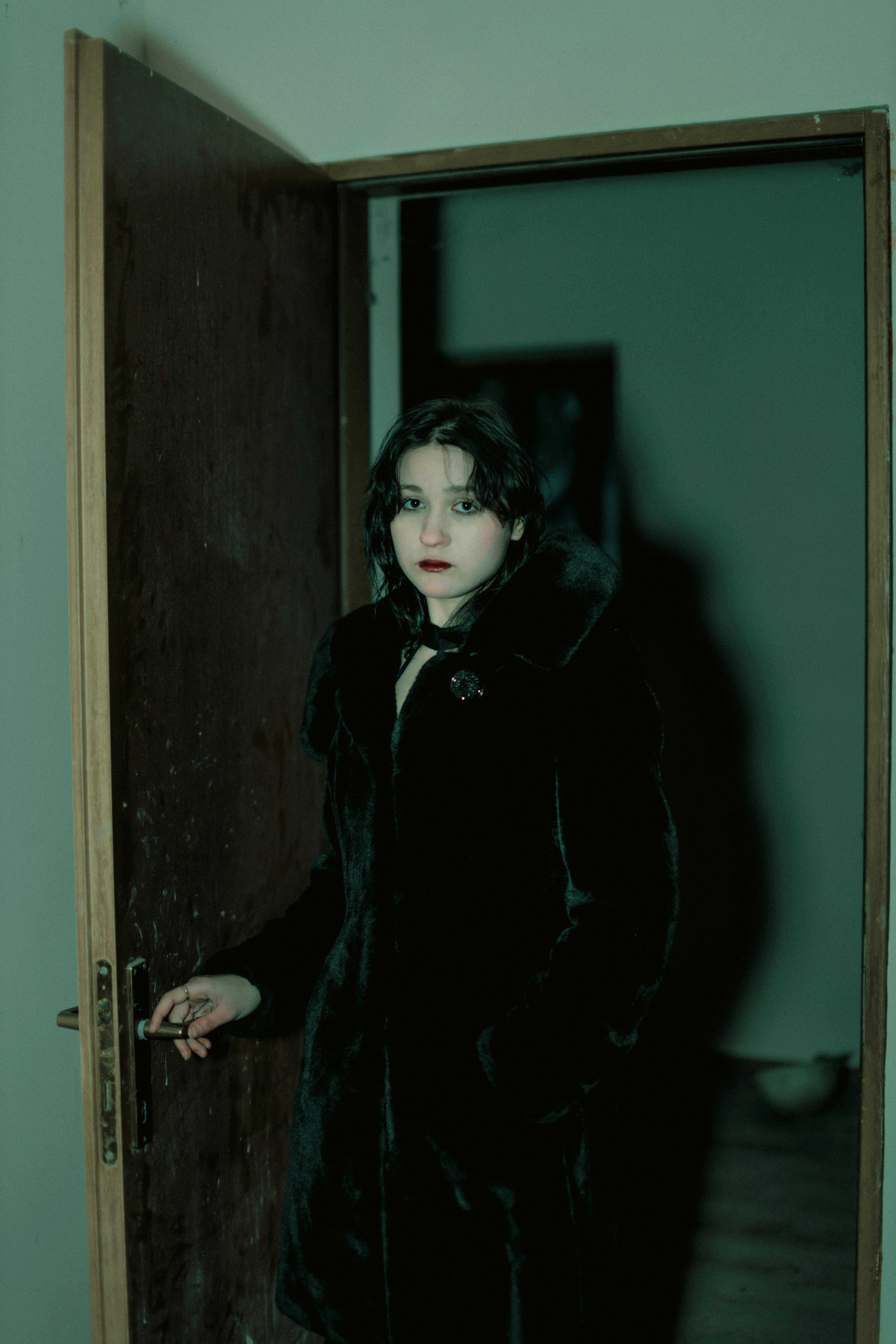 Woman standing by the doorway | Source: Pexels