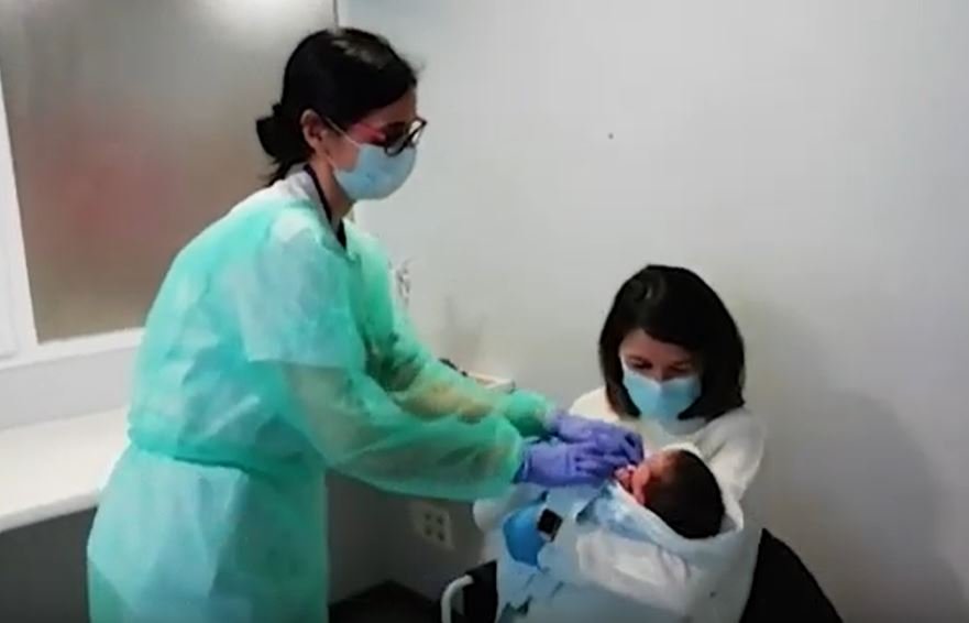Vanesa Muro sosteniendo a su bebé con la ayuda de una enfermera. | Foto: Youtube/ AFP News Agency