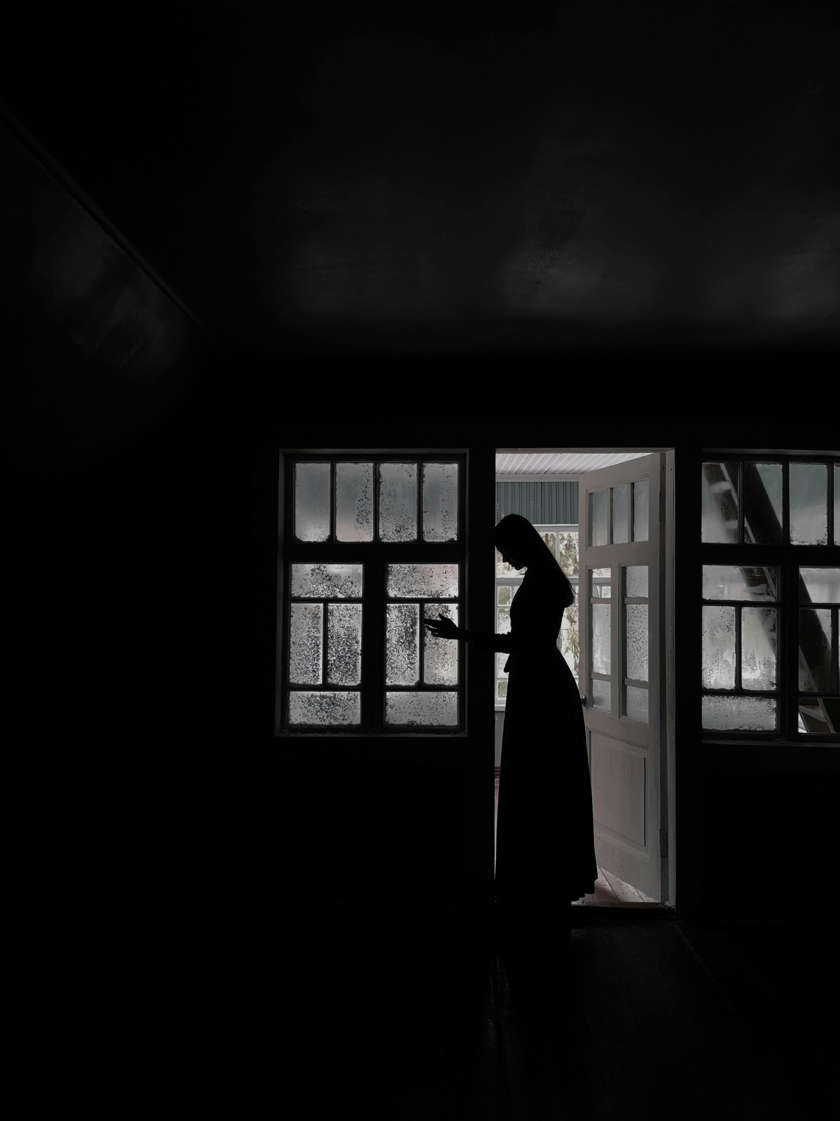 A woman in a long dress standing in doorway | Source: Pexels