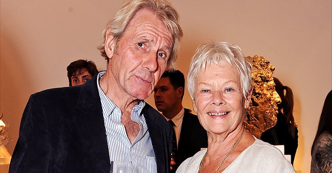David Mills and Dame Judi Dench attend a private viewing for Nicole Farhi's debut exhibition of sculptures, 'From The Neck Up' at Bowman Sculpture on September 16, 2014 in London, England | Photo: Getty Images